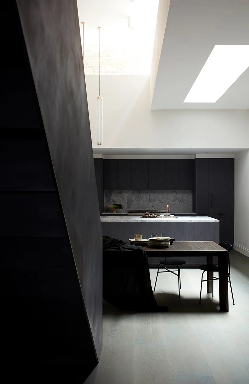 Post-completion photograph of a double-height basement in Kensington with contemporary interiors and a bespoke industrial steel staircase