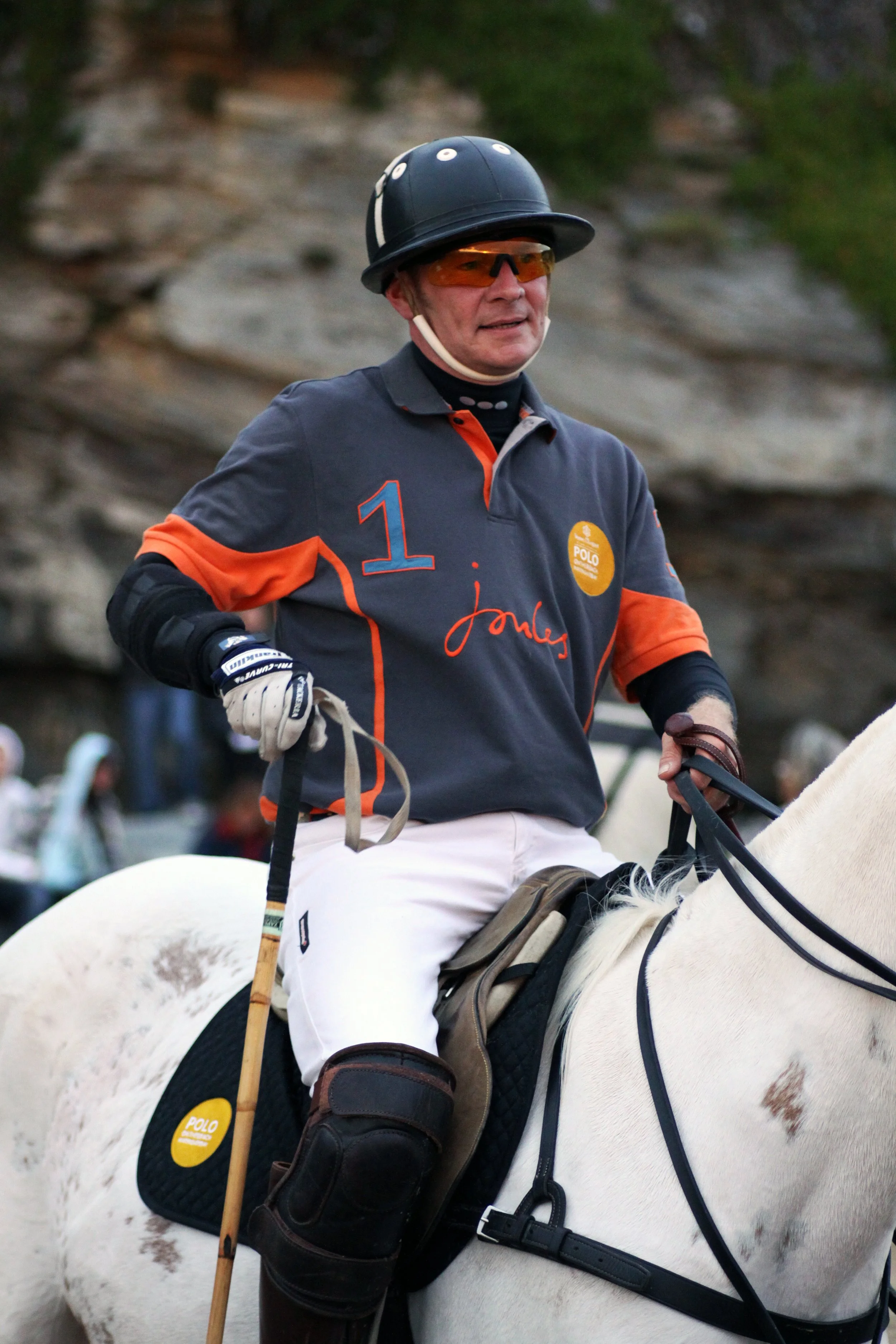 Beach Polo player riding a white horse during a match on Watergate, Newquay, Cornwall