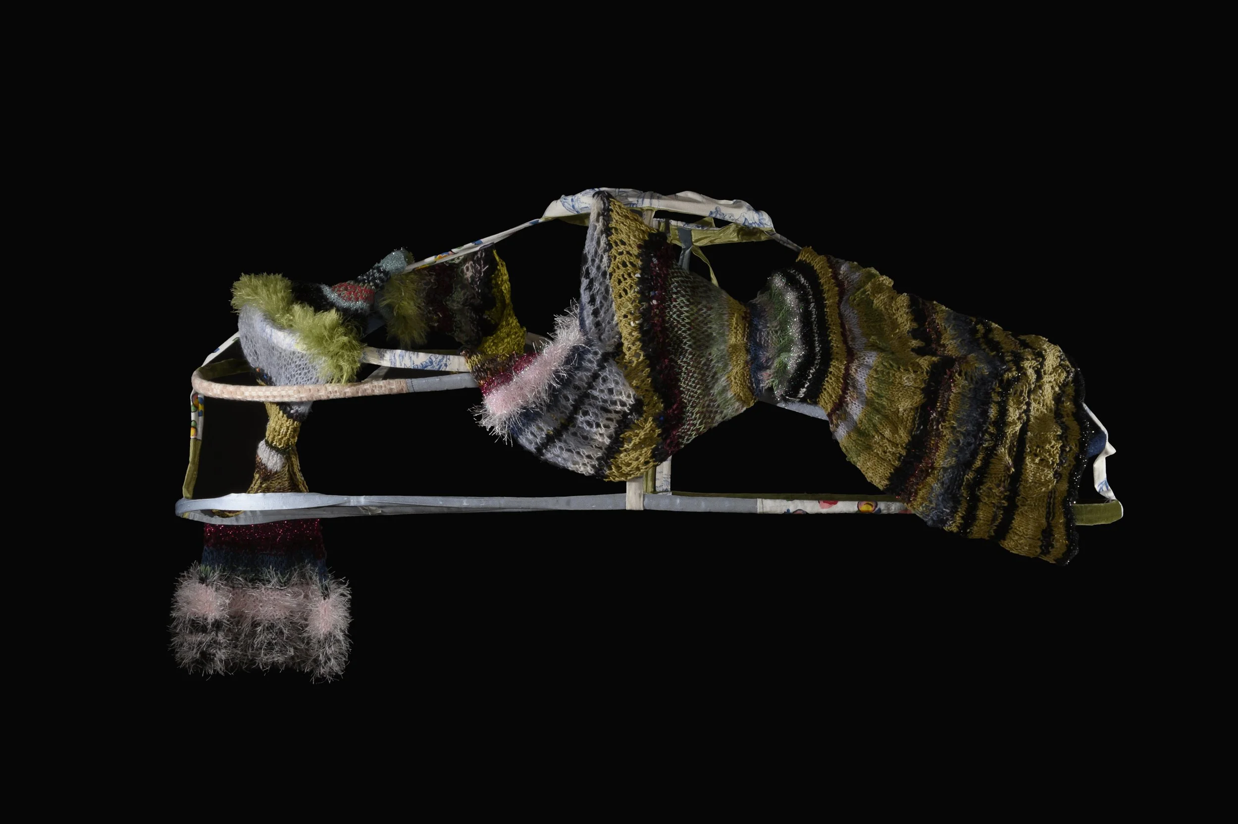 "Scarf." Hand knit scarf totalling 88 inches long, going through various knit structures. Knit freely, jumping between yarns, needles, and structures throughout the knit. Draped over a pannier from the 1750s from Patterns of Fashion Volume 5.