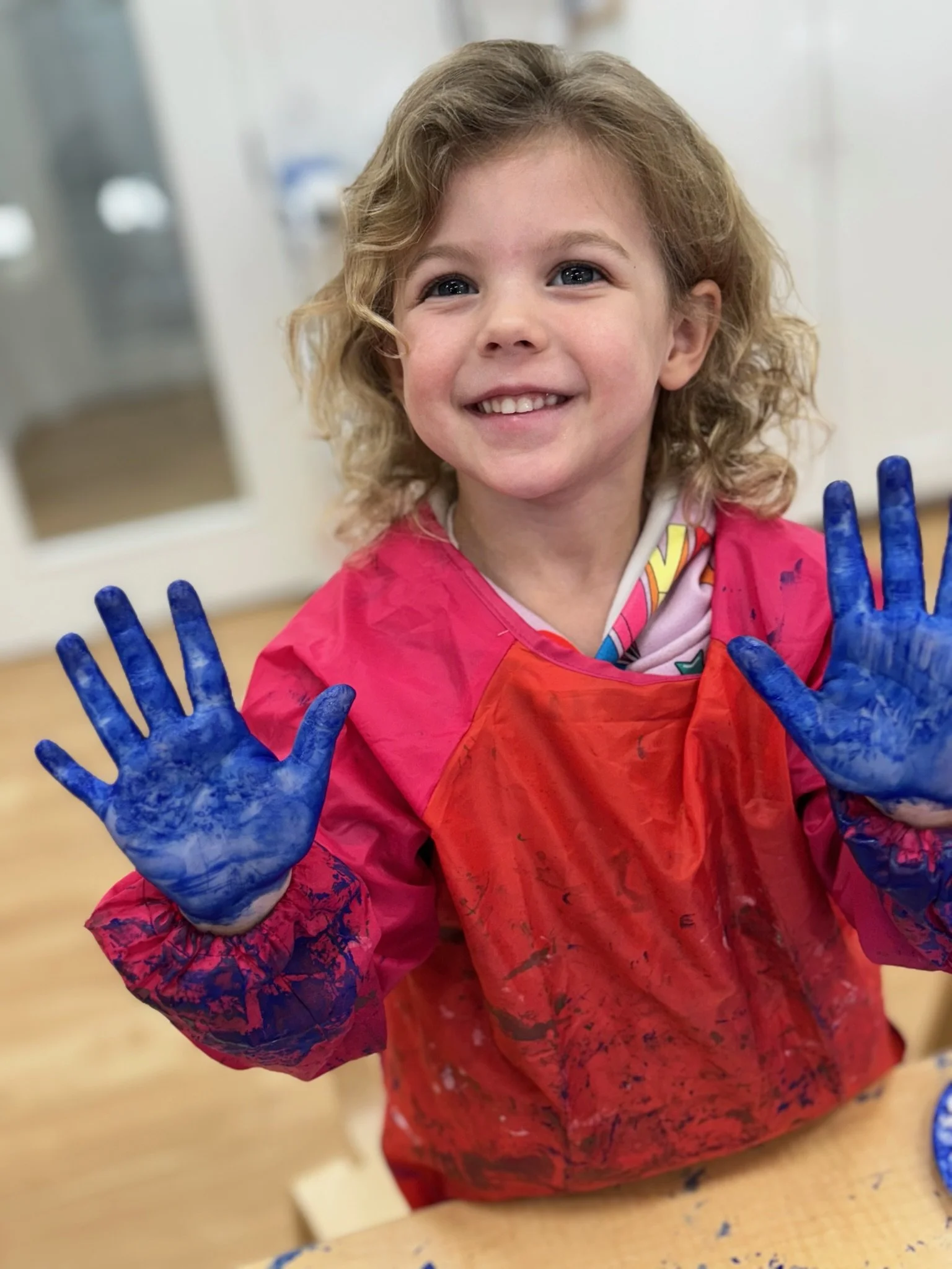 Little girl with paint on her hands.