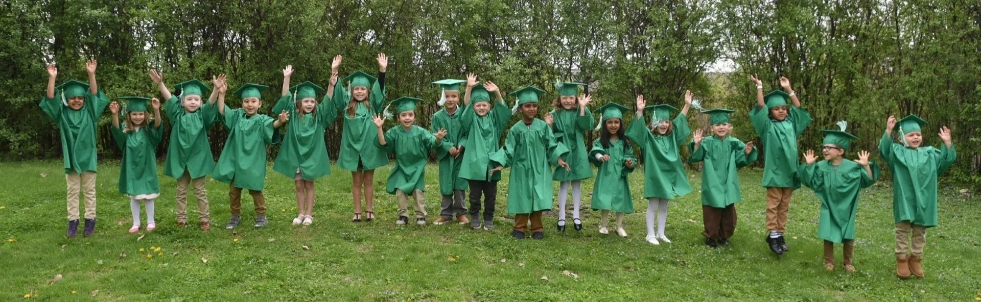 Kids jumping in graduation robes.
