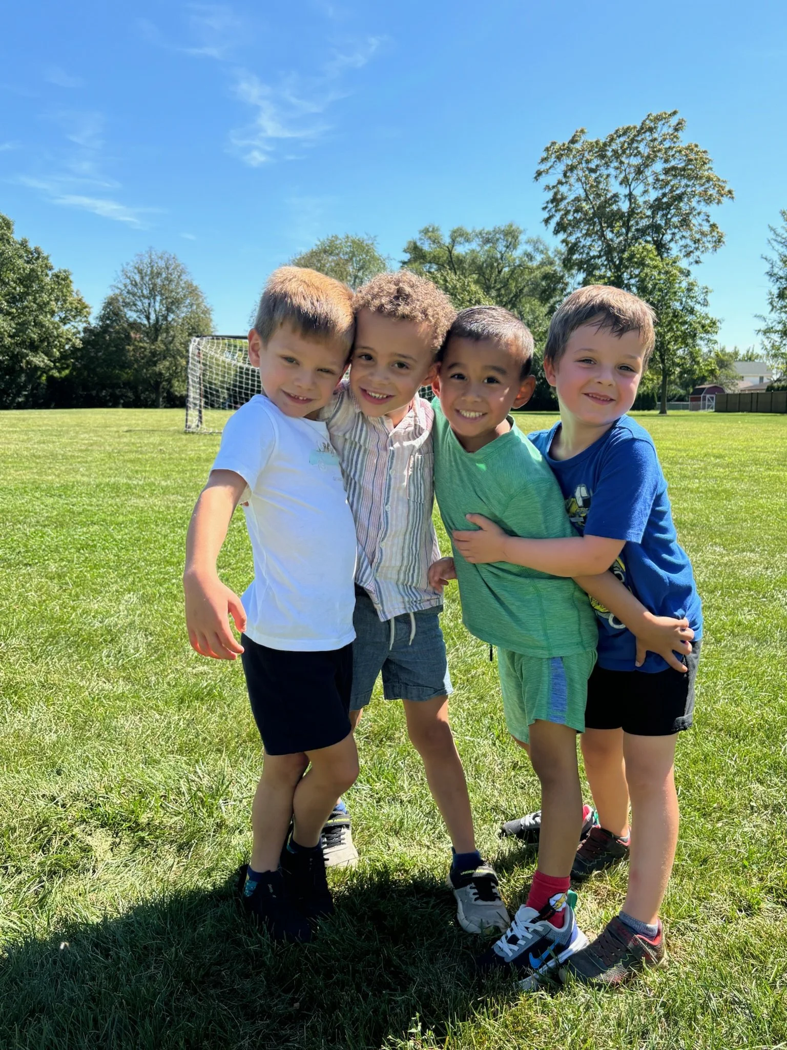 Kids posing for a photo on a soccer field.