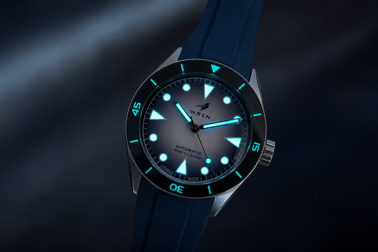 Wren dive watch lume glowing in low light on a rubber strap