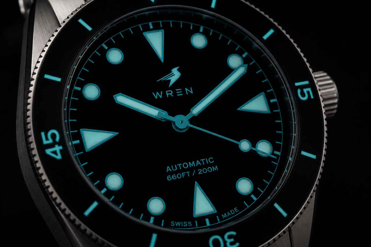 Close-up of the Wren Diver One Abyss dial in Musou Black, the lumed markers floating against an unlit surface