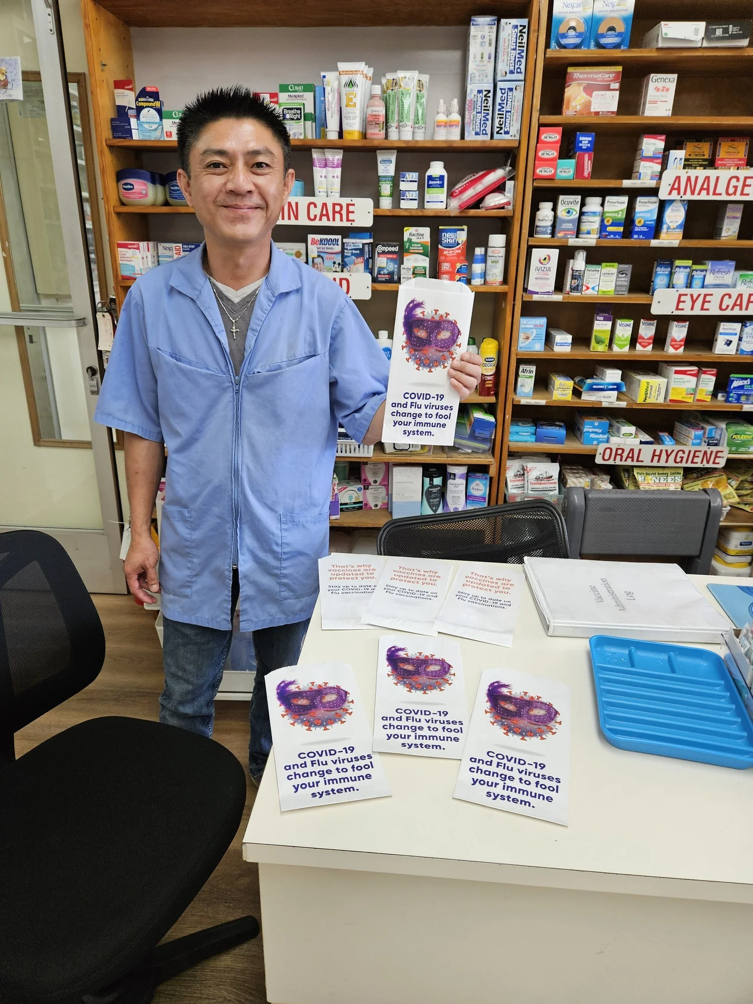 Pharmacist holding a COVID-19 and flu vaccination pharmacy bag at the counter