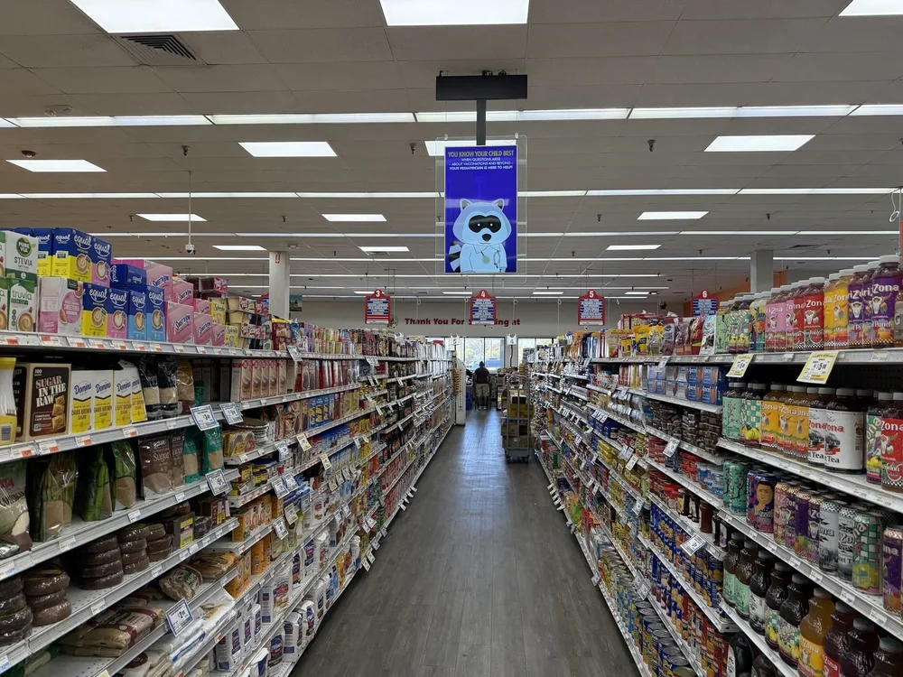 Digital screen hanging over a grocery store aisle