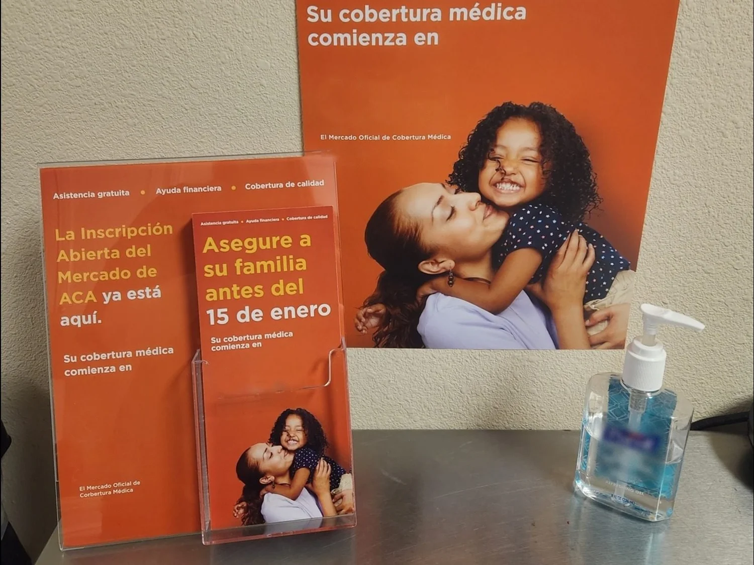 Spanish-language health-coverage poster and brochure stand in a clinic