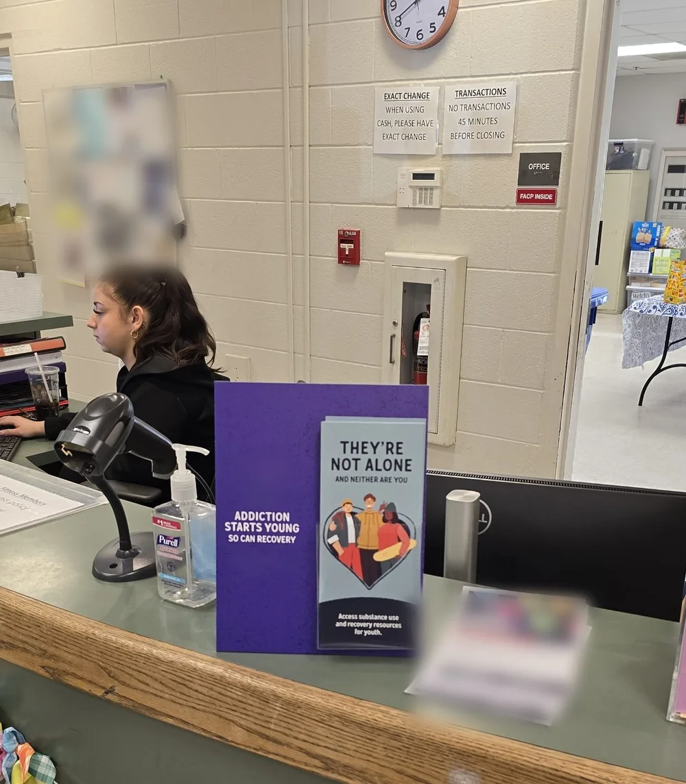 Prevention take-one cards in a counter display on a school front desk