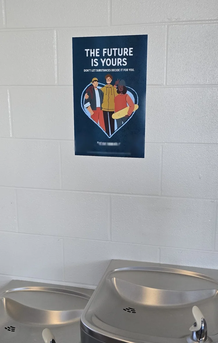 Substance prevention poster on a tiled wall above school water fountains