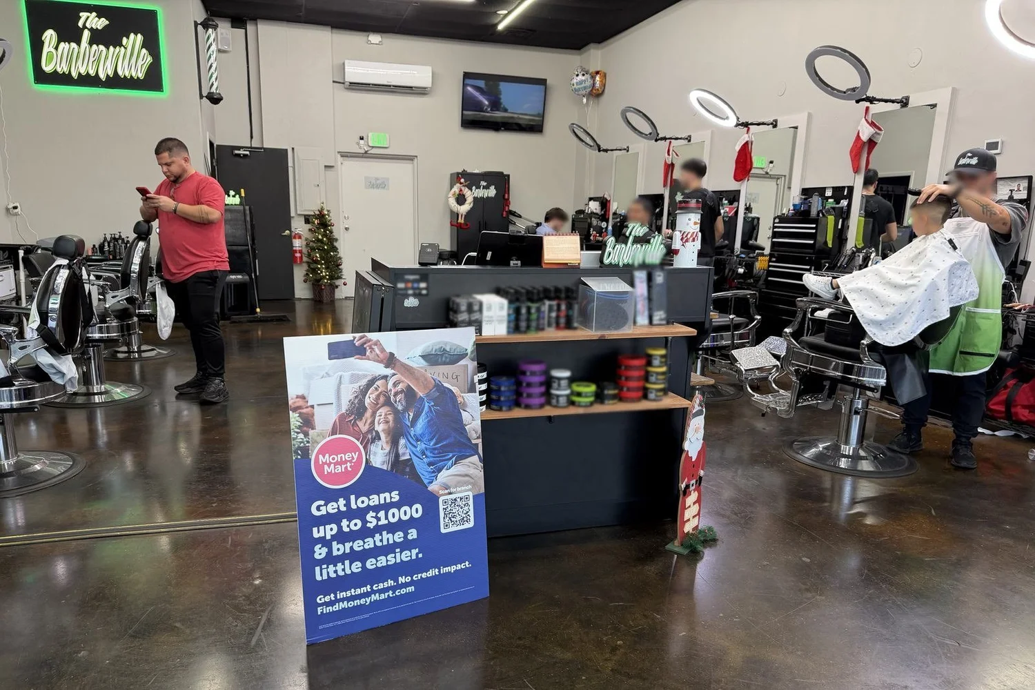 Floor standee beside the retail shelf inside a busy barbershop