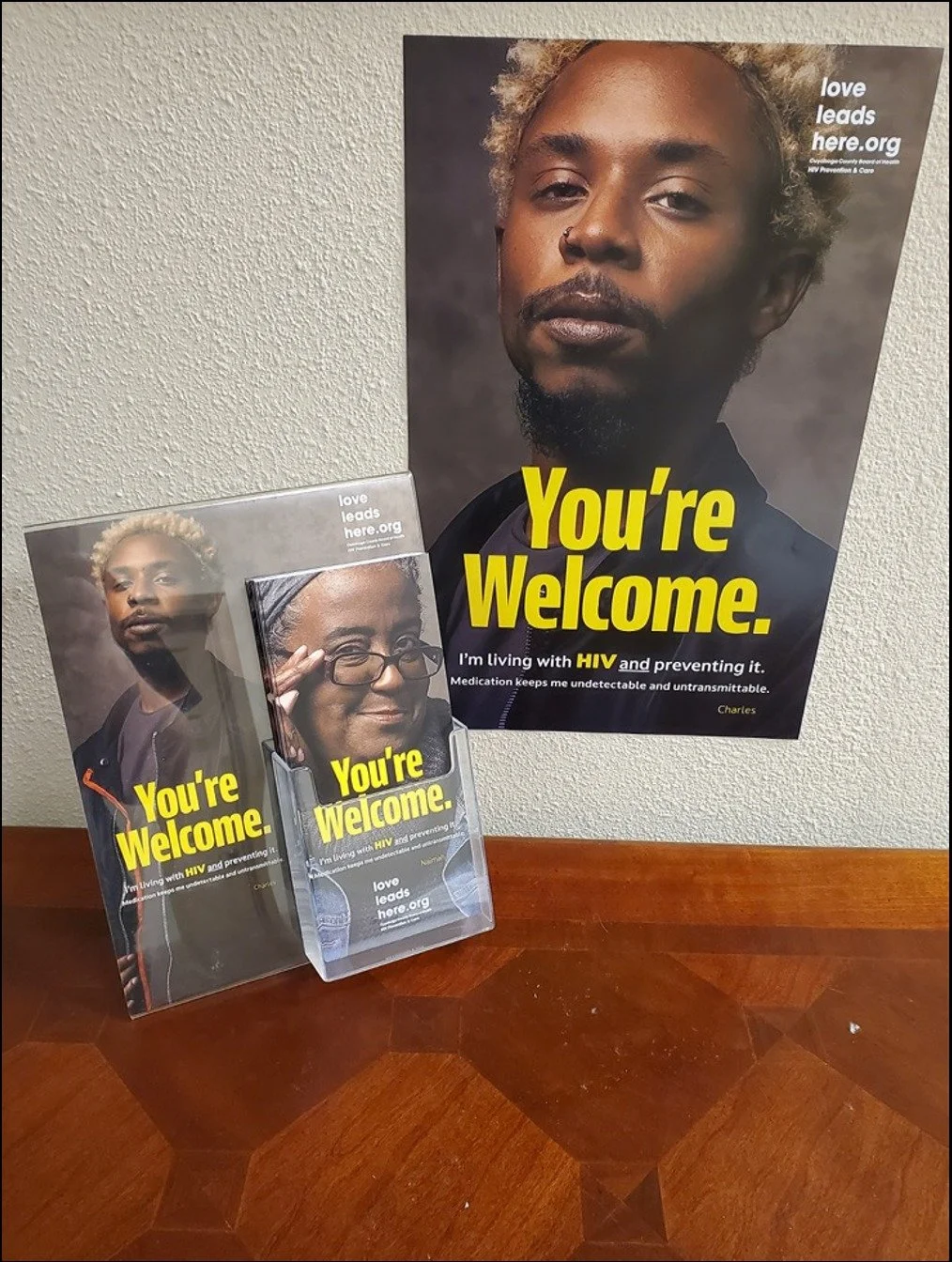HIV prevention poster on a clinic wall above a matching brochure and take-one card holder