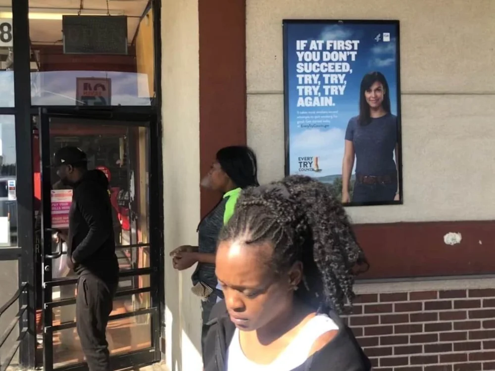 Health poster at a store entrance as shoppers walk in