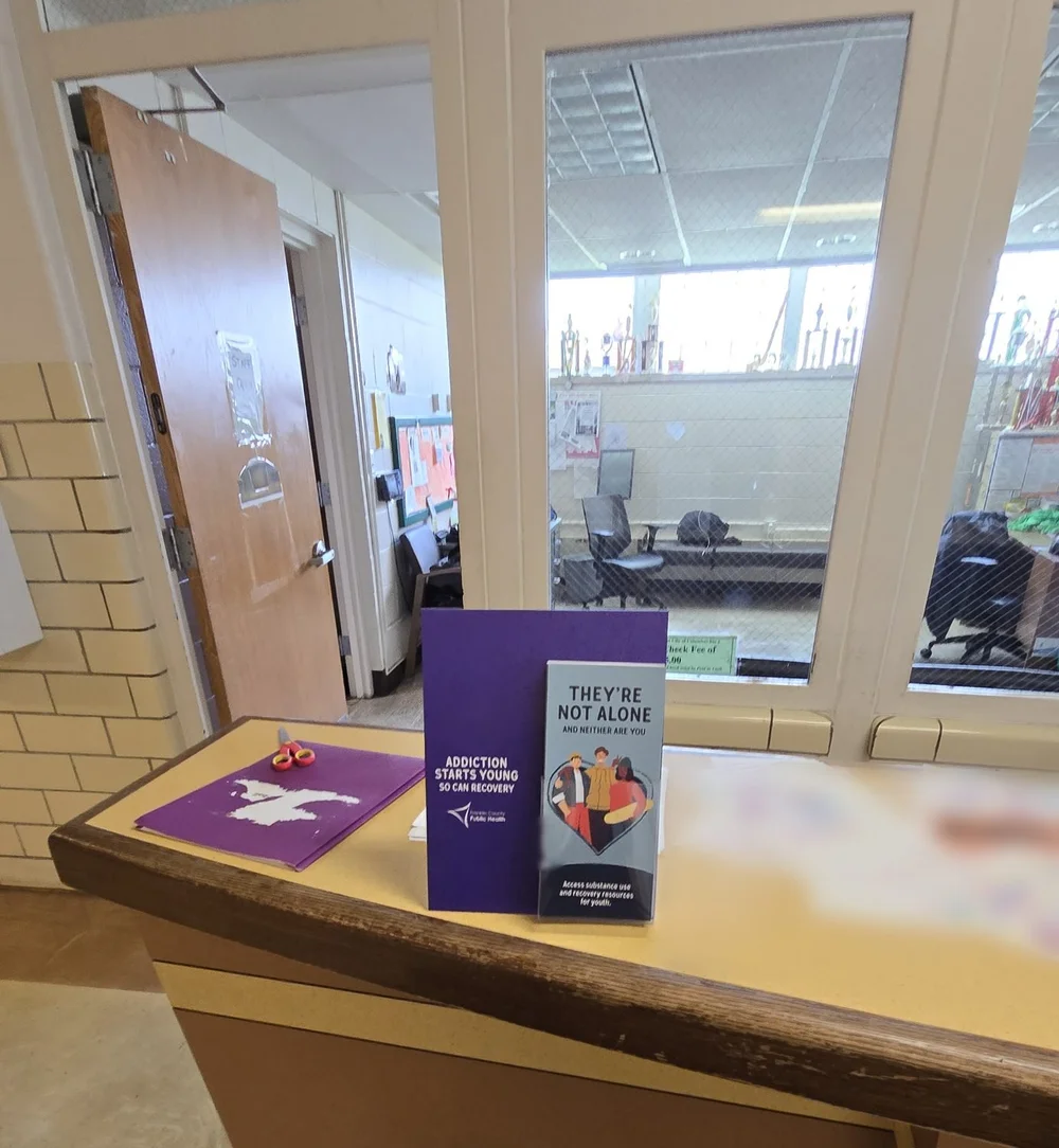 Prevention take-one cards in a counter display on a school office counter