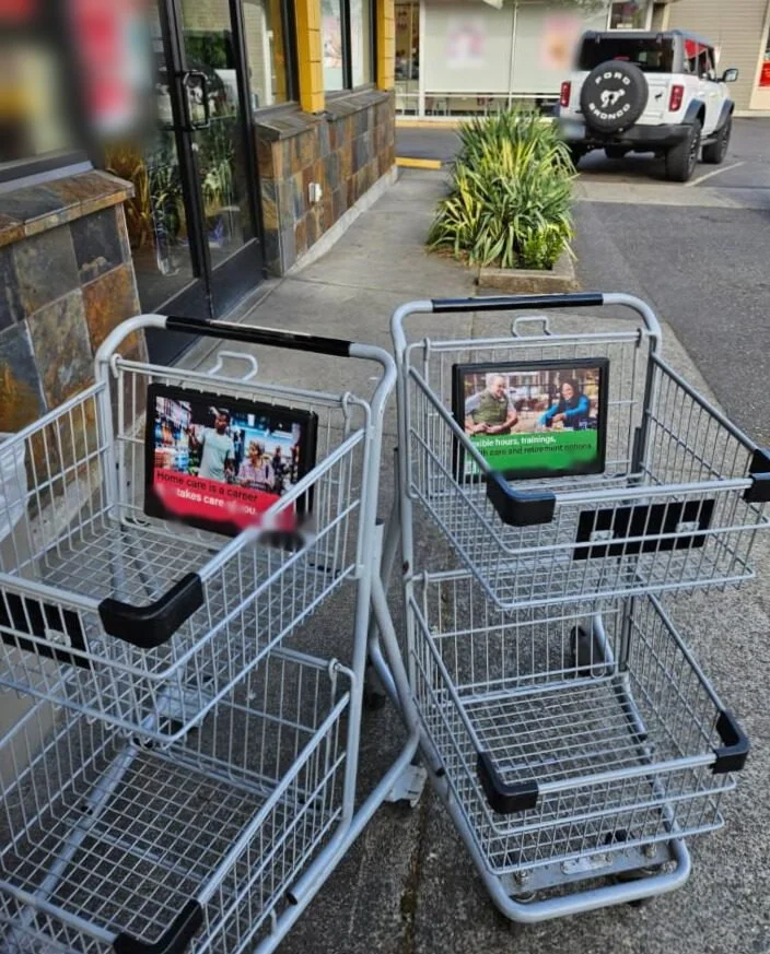 Two shopping carts with ads on the front panels outside a store entrance