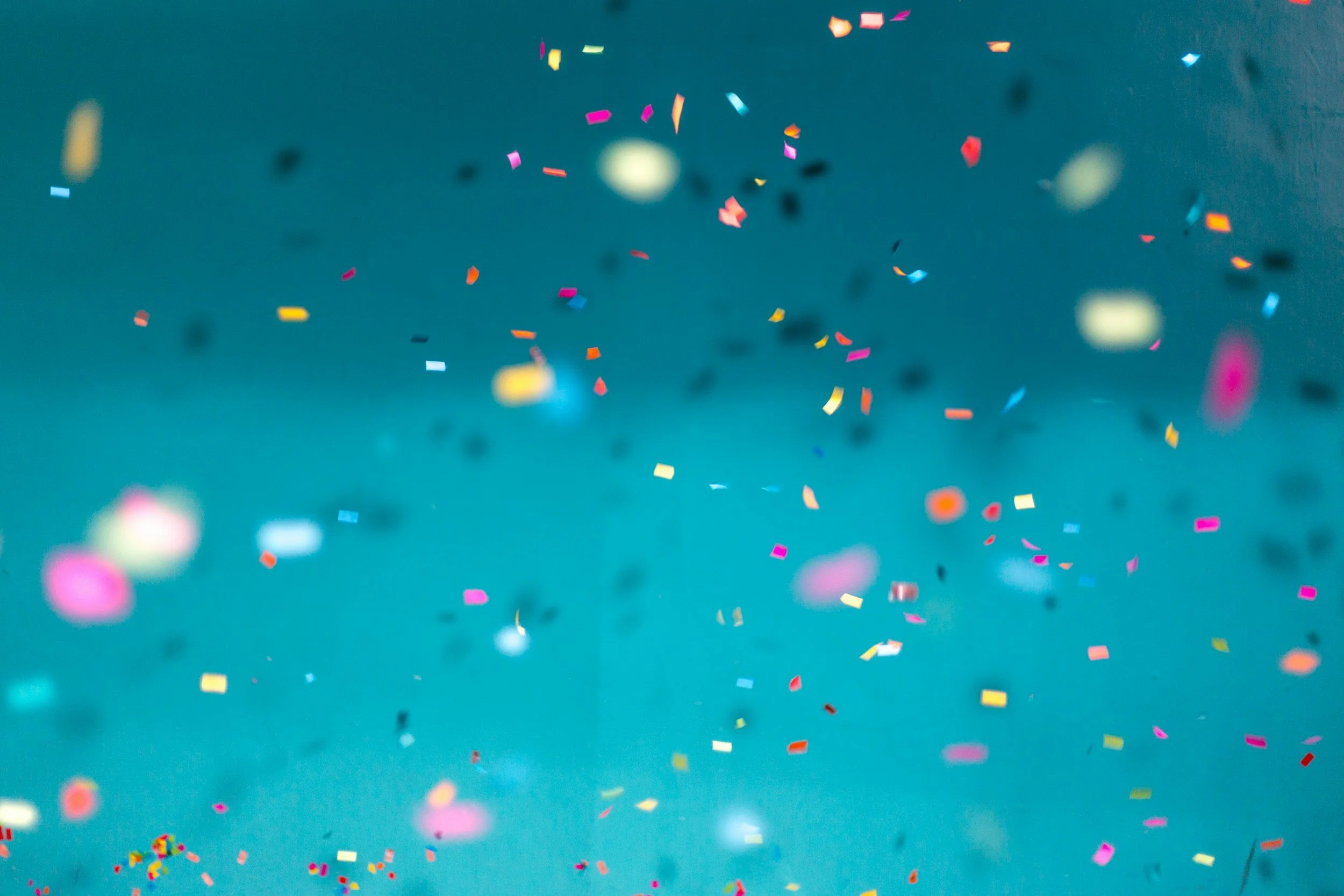 Colorful confetti falling against a blue background.