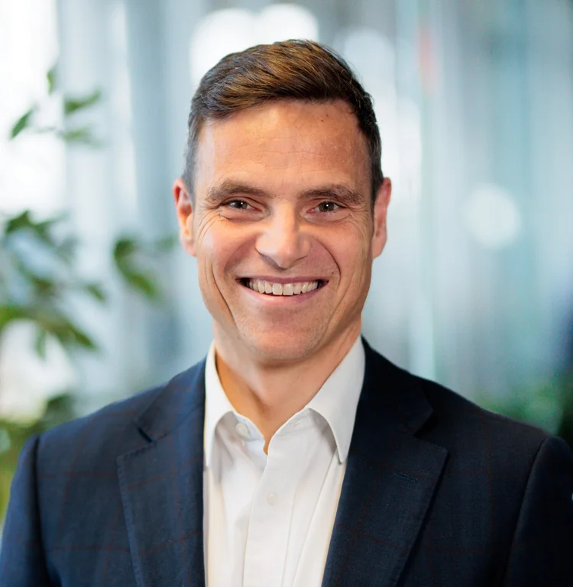 Drew Beswick, NDIS Support Coordinator at ARK Planit, smiling in a professional indoor portrait.