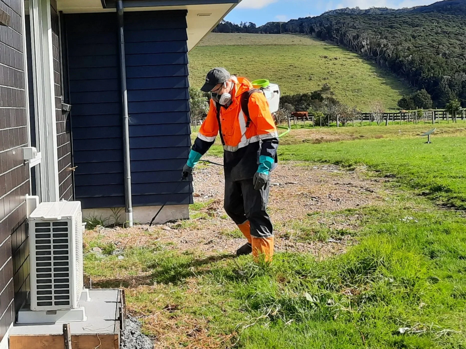 Man in safety gear spraying outdoors