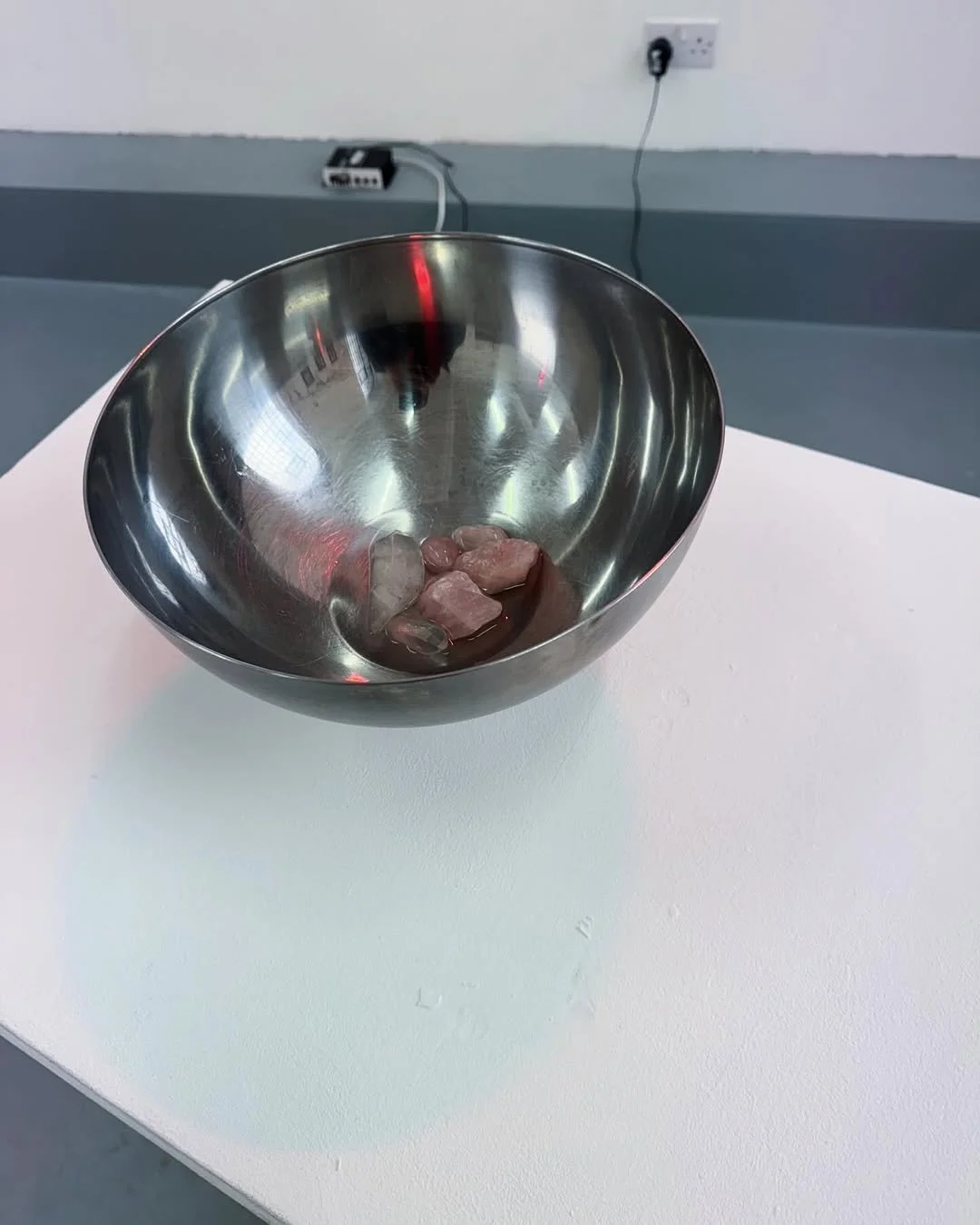 Muddy Puddles (2025) Sound installation with distorted children’s television audio, stainless steel bowl, rose quartz, quartz, water, amplifier, and audio exciter.