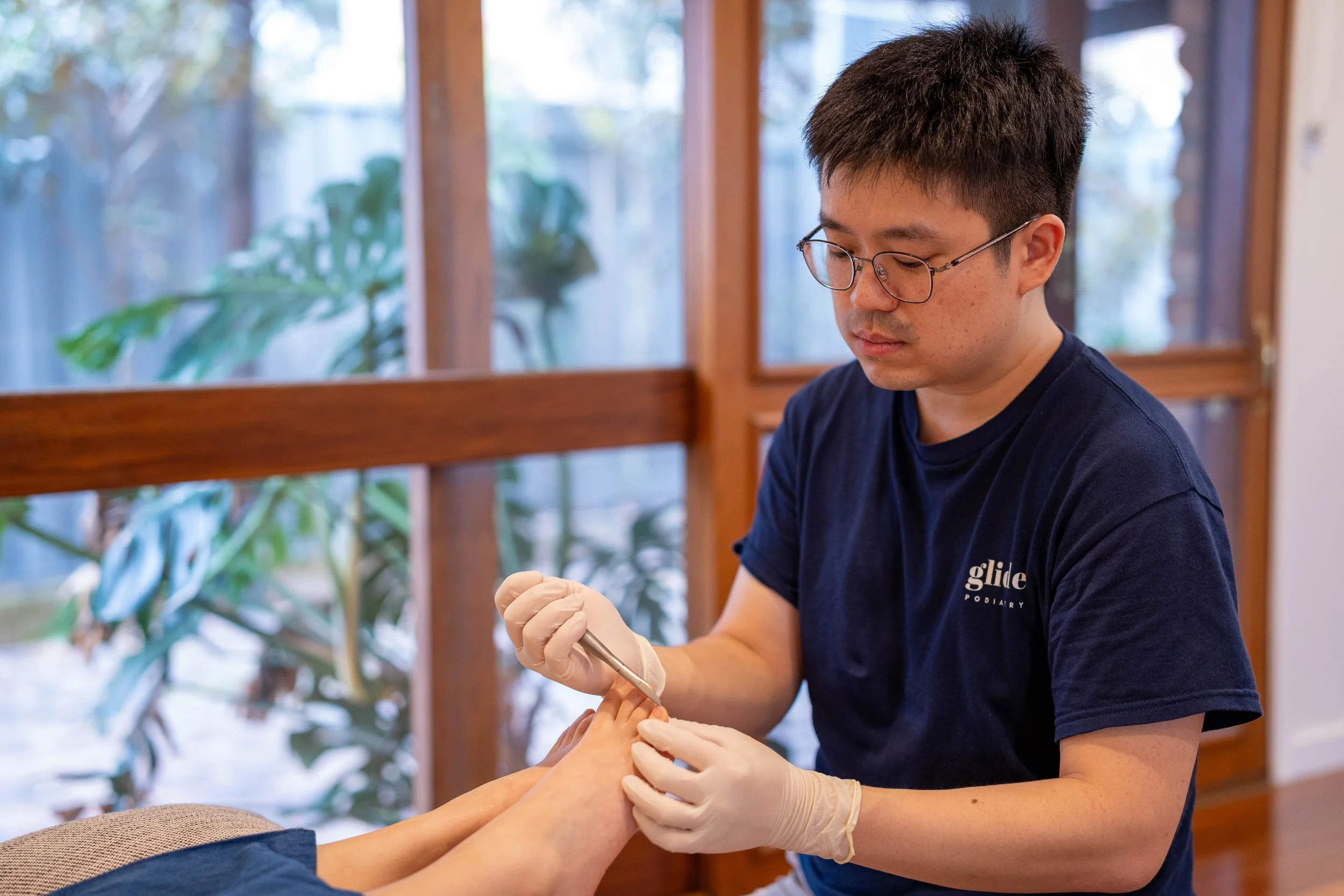 Podiatrist treating an ingrown toenail to relieve pain, swelling, and infection risk.