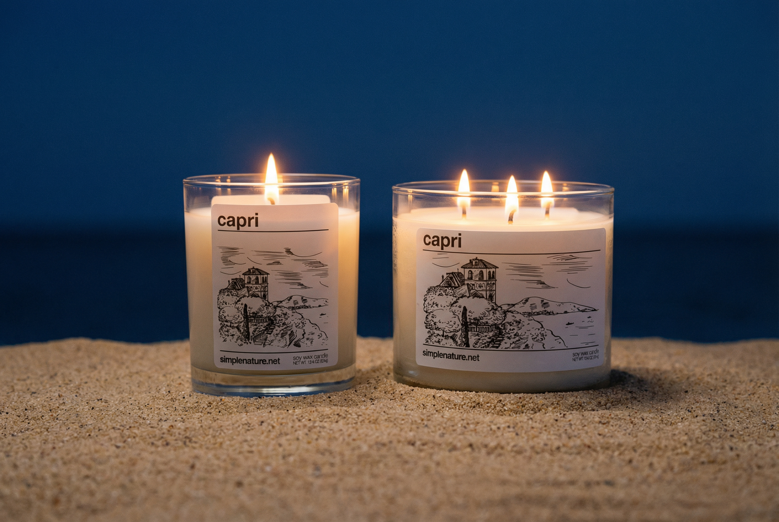 Two lit candles on sandy surface against blue background, labeled 'capri' with illustrations of a seaside landscape.