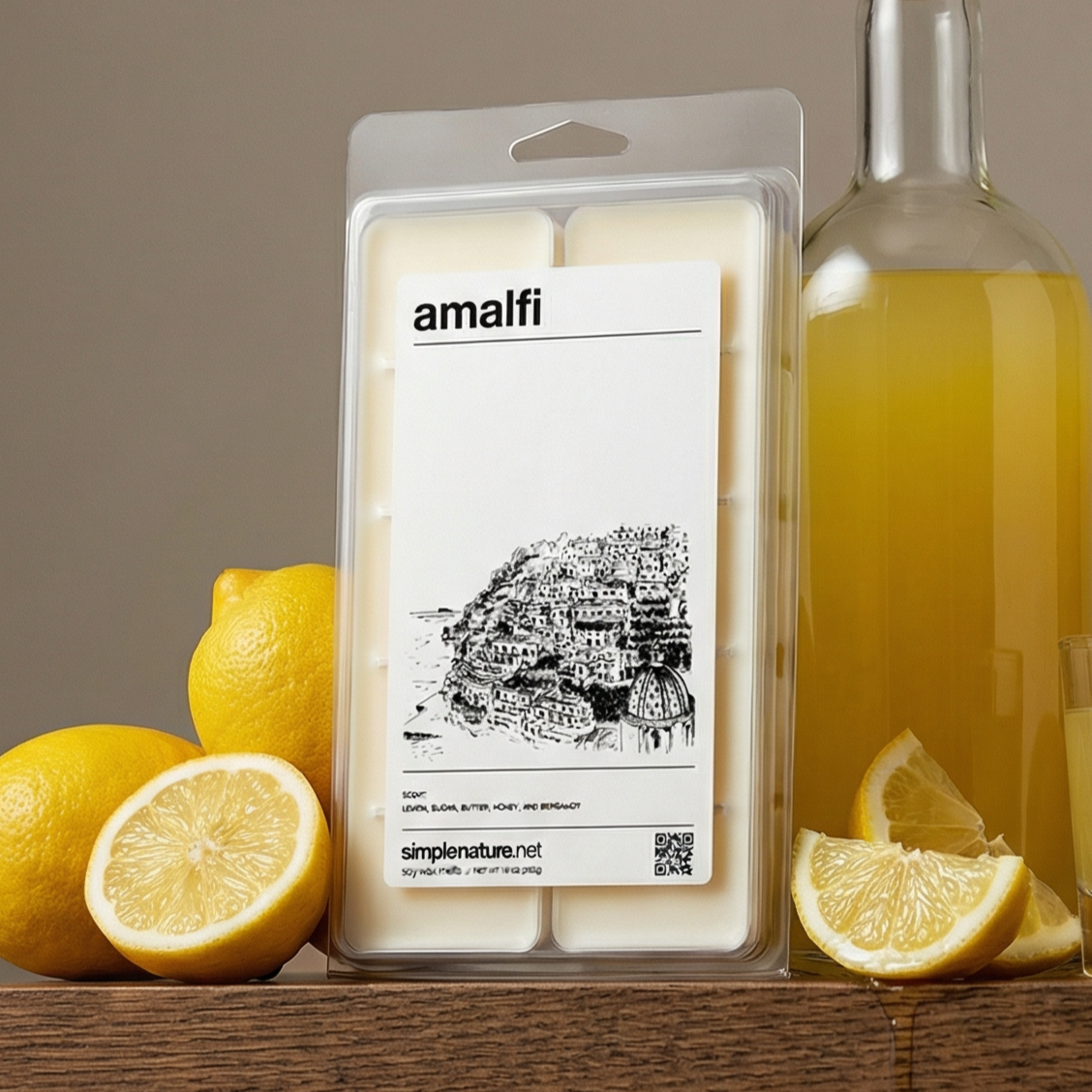 Lemon slices, whole lemons, a bottle of olive oil, and a package of Amalfi flavored wax melts are arranged on a wooden surface.