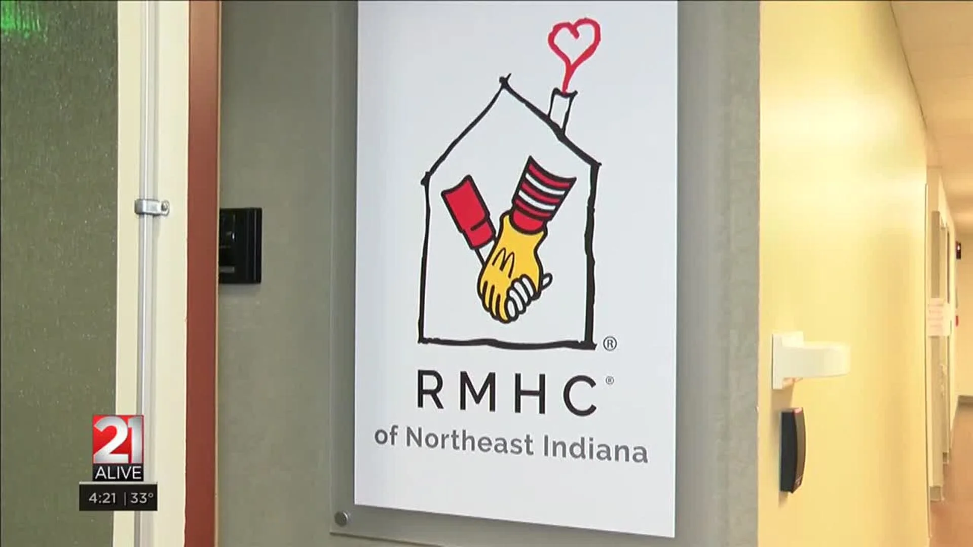 Lit scented candle labeled "home away from home" on a wooden table with a bookshelf in the background.