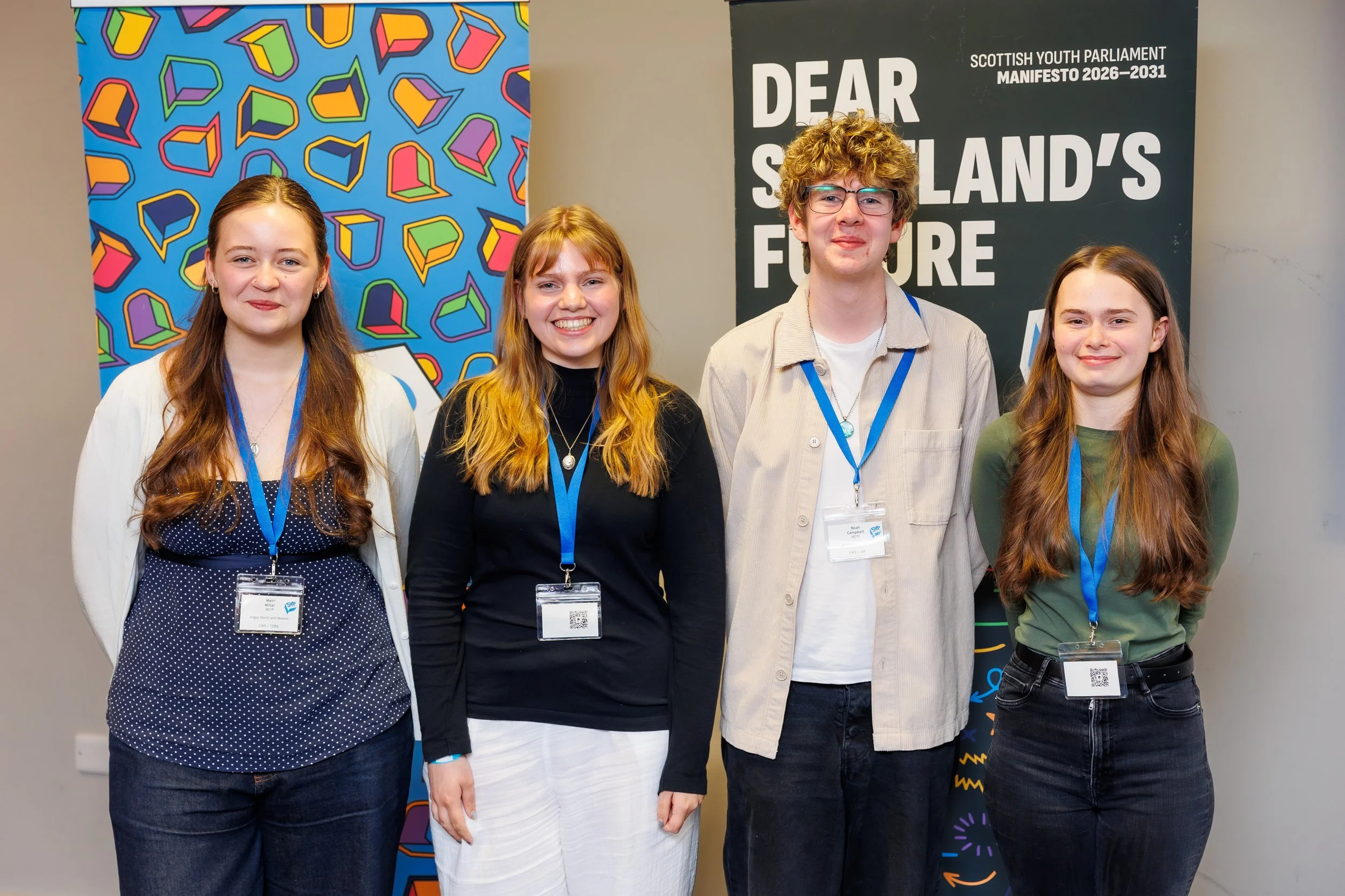 Members of the Scottish Youth Parliament for Aberdeenshire pausing for the camera, with SYP banners in the background