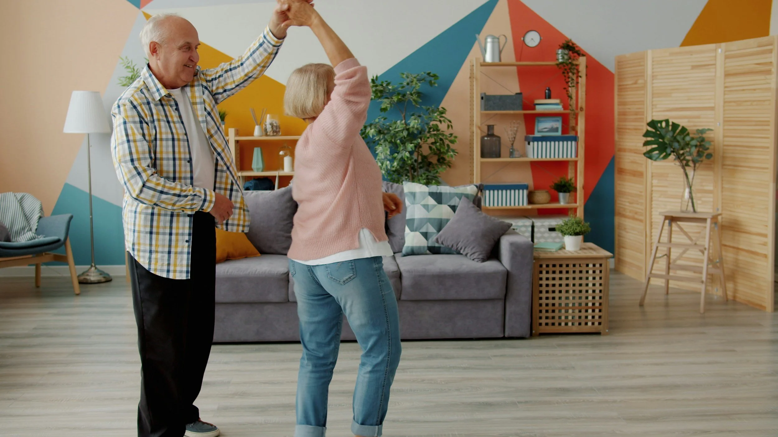 Seniors dancing in decluttered, downsized living space.