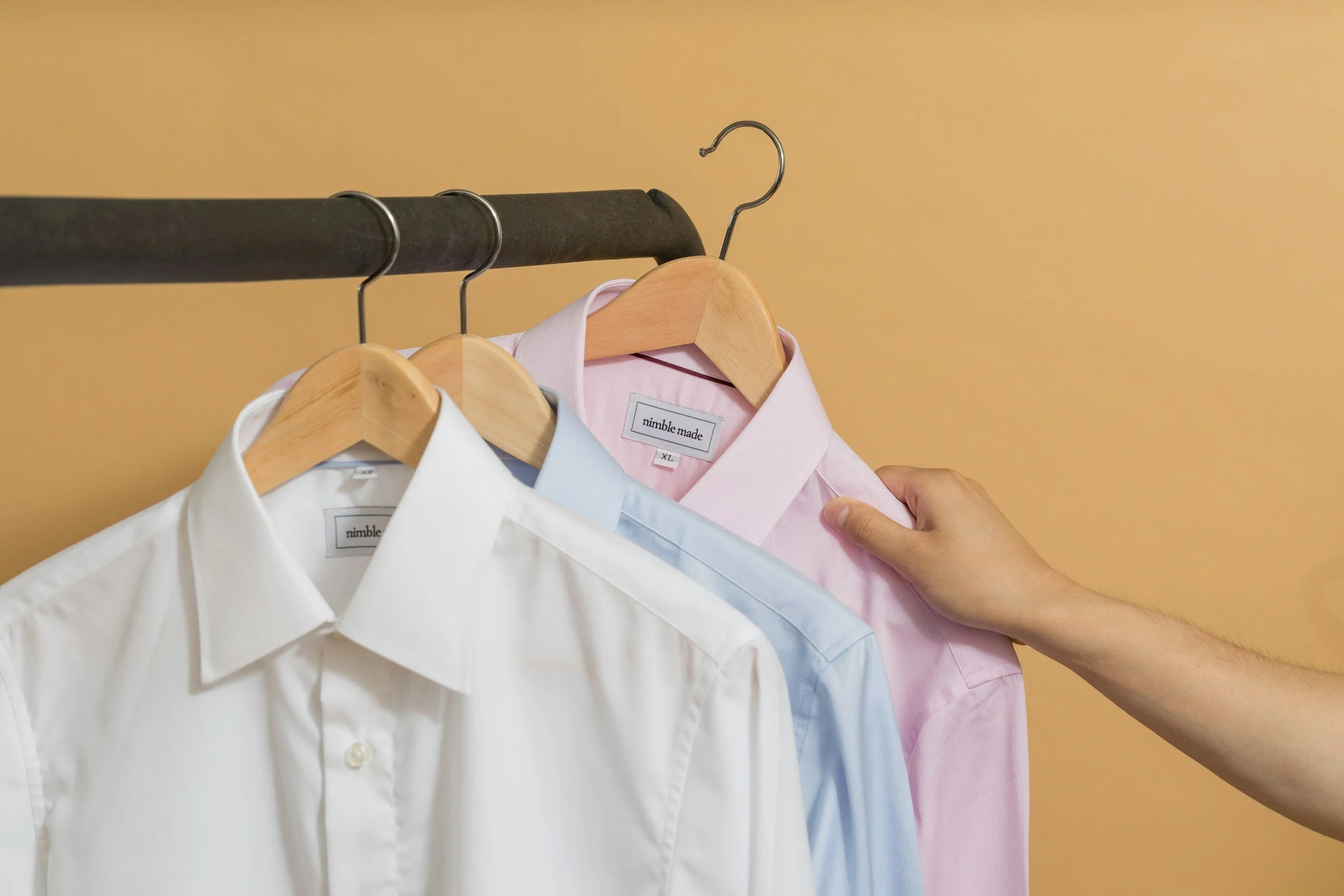 Clothes on hangers in decluttered, downsized closet space.