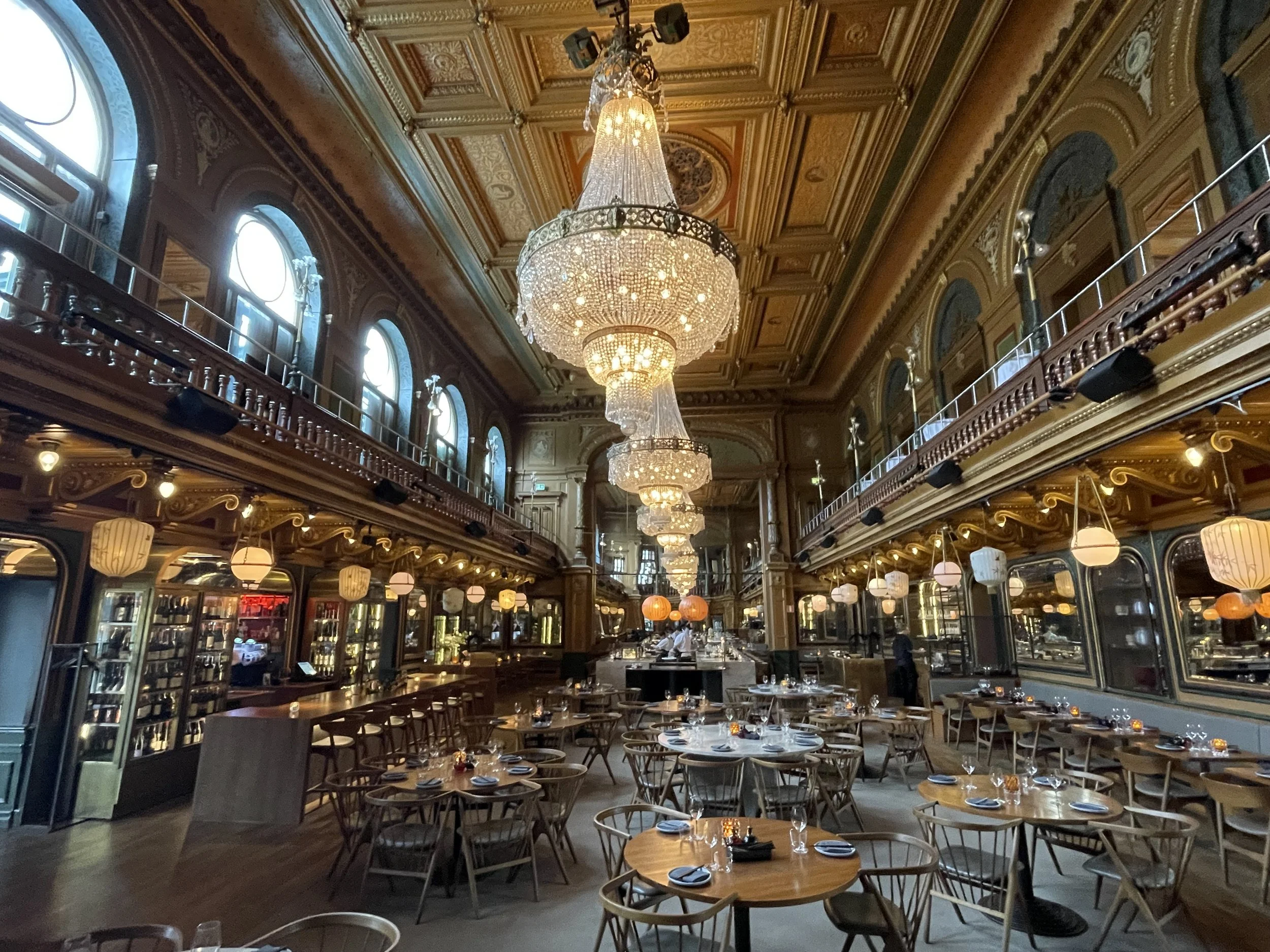 An image of Berns restaurant in Stockholm showing the restaurant with big chandeliers, architecture and tables.
