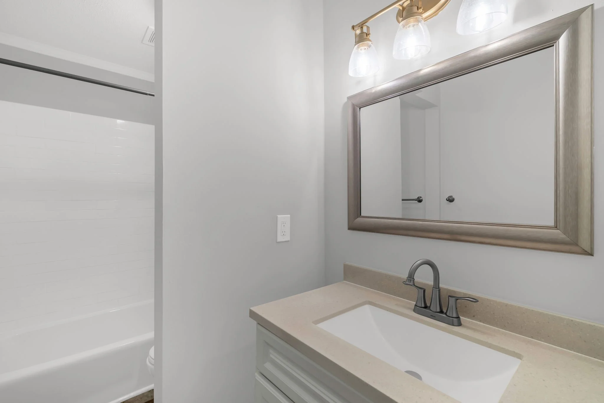 Secondary bathroom view highlighting storage and lighting