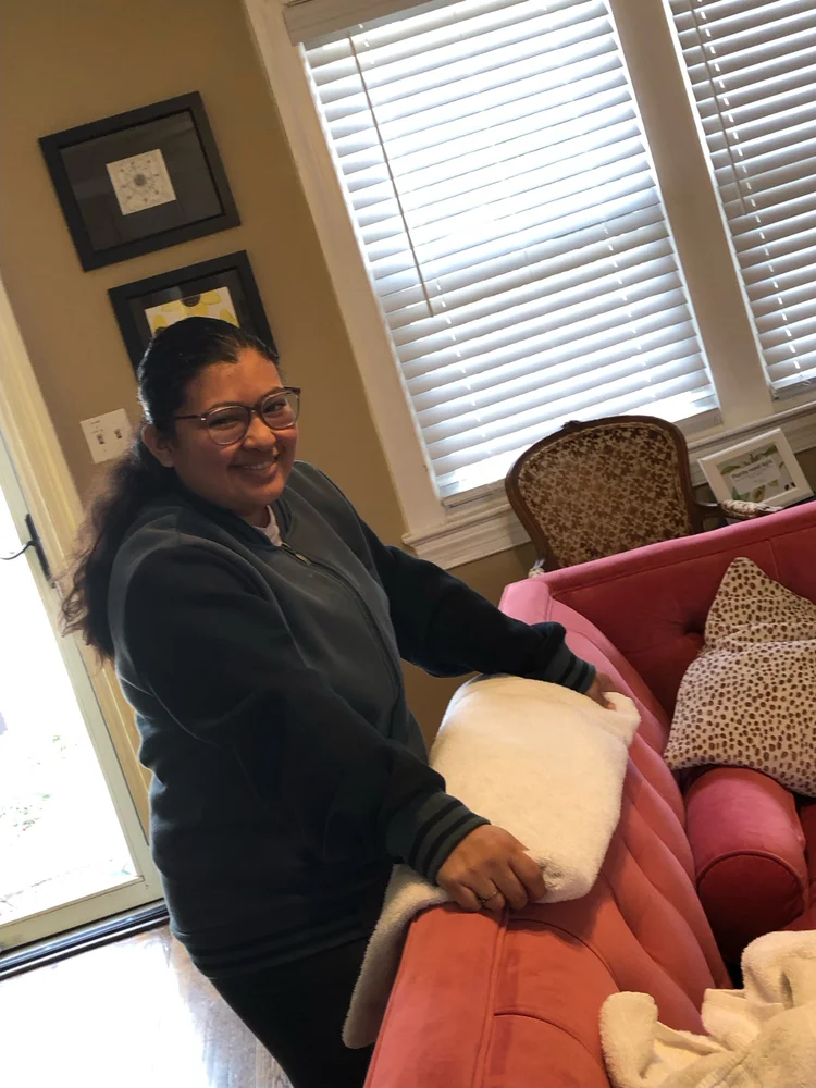 An apprentice folding towels, practicing the domestic arts