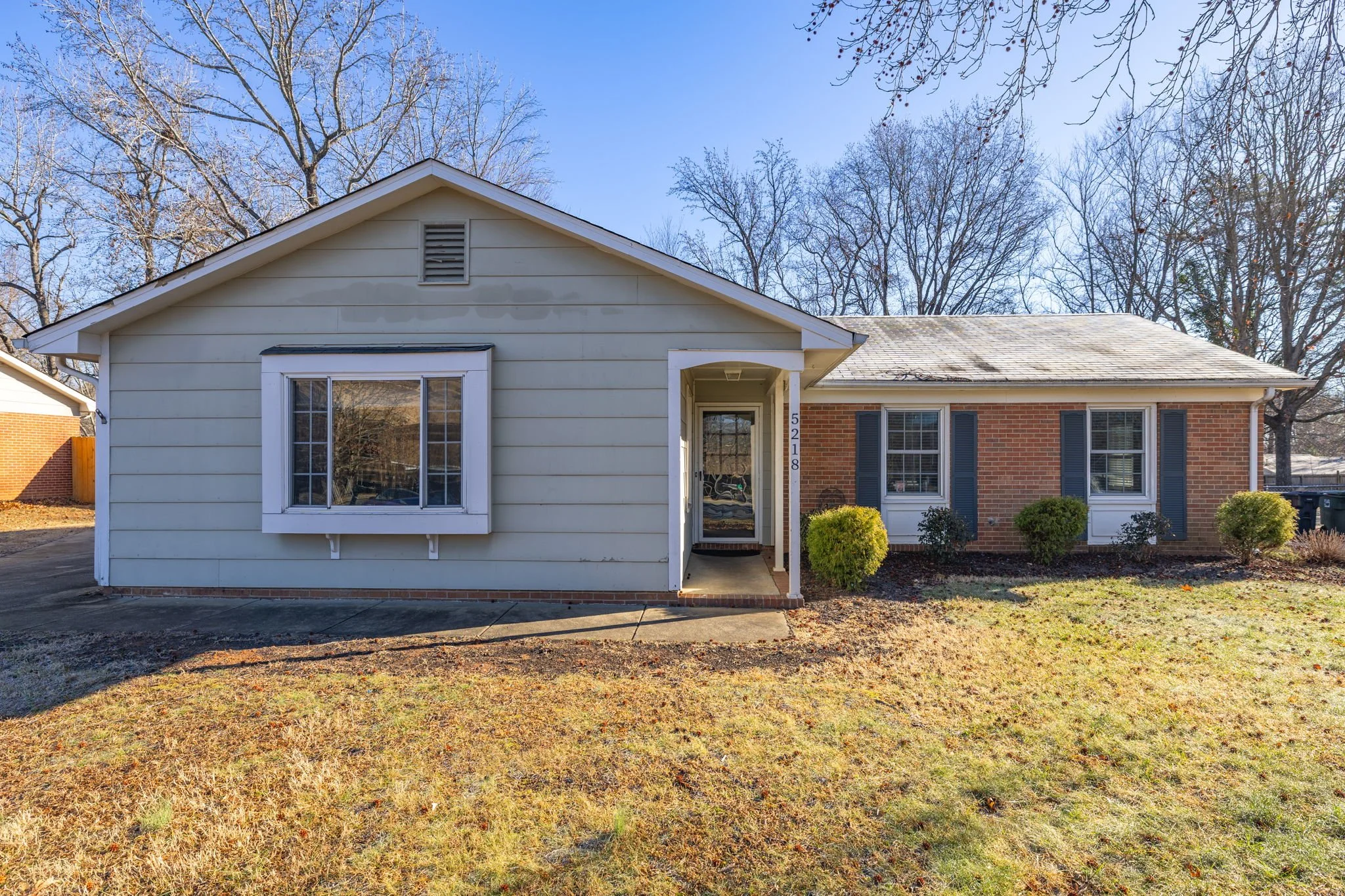 Front exterior of 5218 Lawndale Dr in Greensboro NC featuring classic brick construction and mature landscaping