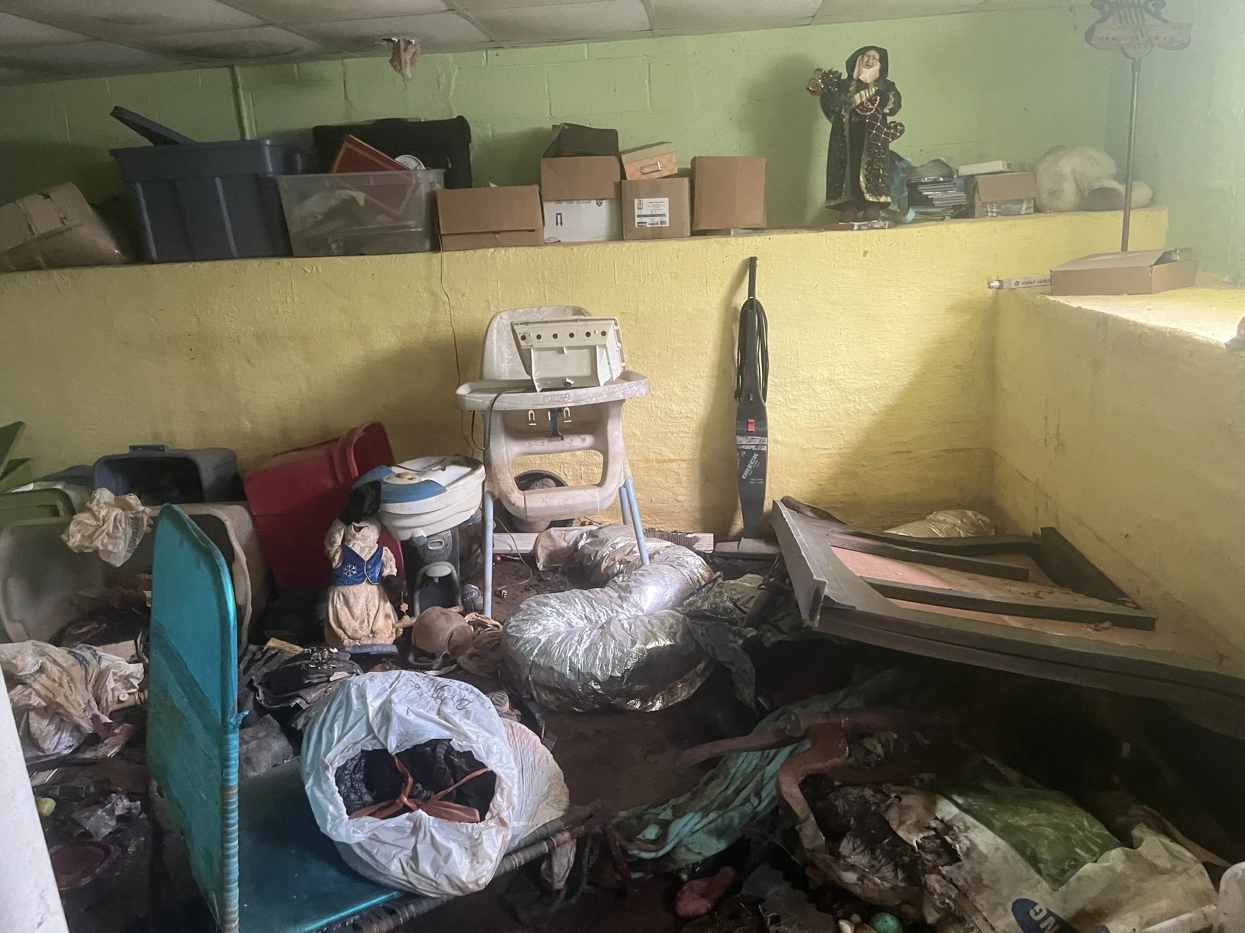  This is the basement in the beginning. Everything on the floor was wet. We later learned that the water was coming from a broken water line between the street and the connection with the house.  