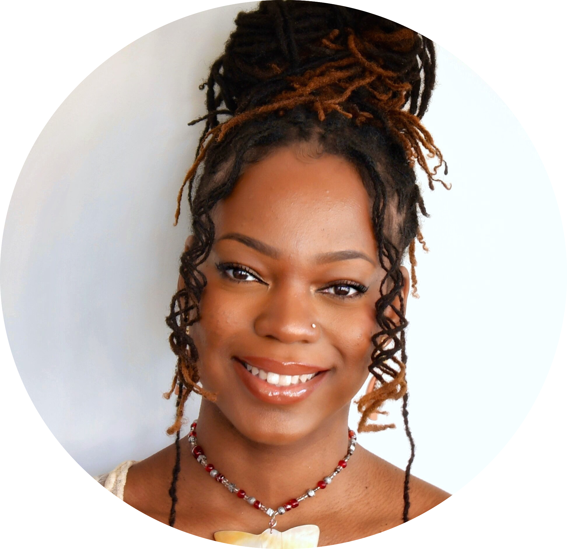 Portrait of a smiling woman with braided hair styled in a high bun, wearing a nose stud, necklace, and glossy makeup, against a white background.