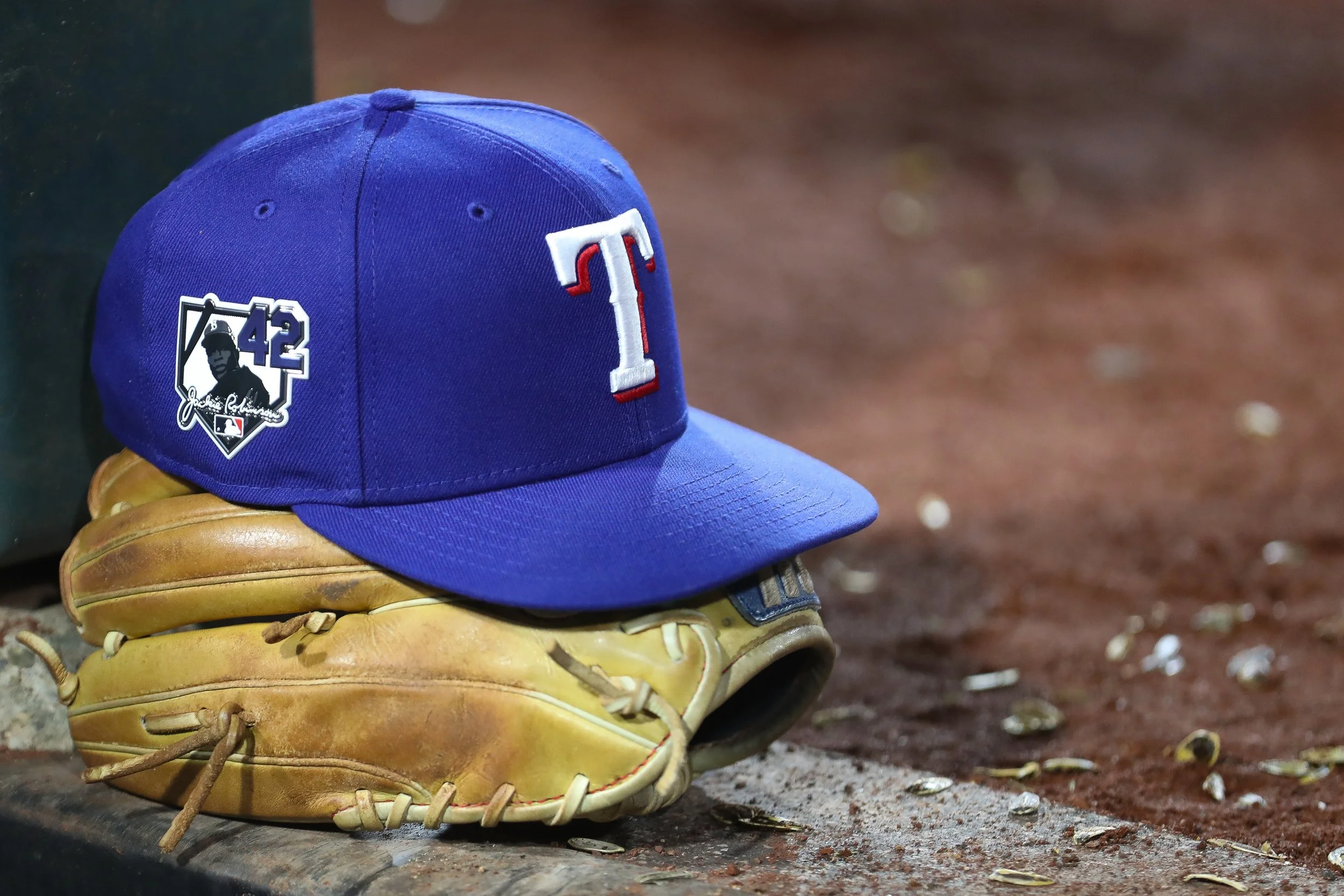 A general view of a hat and glove worn by a Texas Rangers player during the seventh inning of a baseball game against the Athletics Wednesday, April 15, 2026, in West Sacramento, Calif. (AP Photo/Scott Marshall)