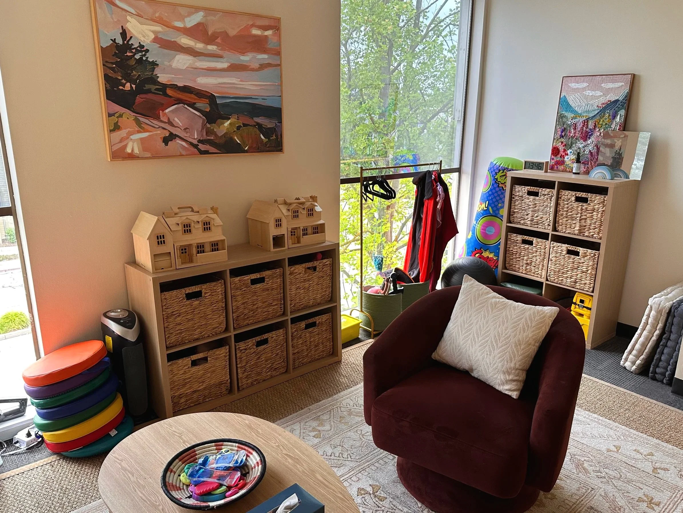 Cozy seating, bookshelves filled with thoughtful resources, and handmade wall art. Our expressive arts therapy space feels like somewhere you would actually want to spend time.