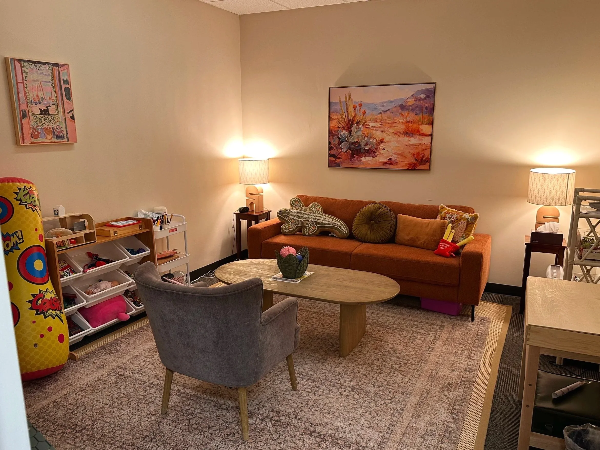 Cozy seating, bookshelves filled with thoughtful resources, and handmade wall art. Our expressive arts therapy space feels like somewhere you would actually want to spend time.