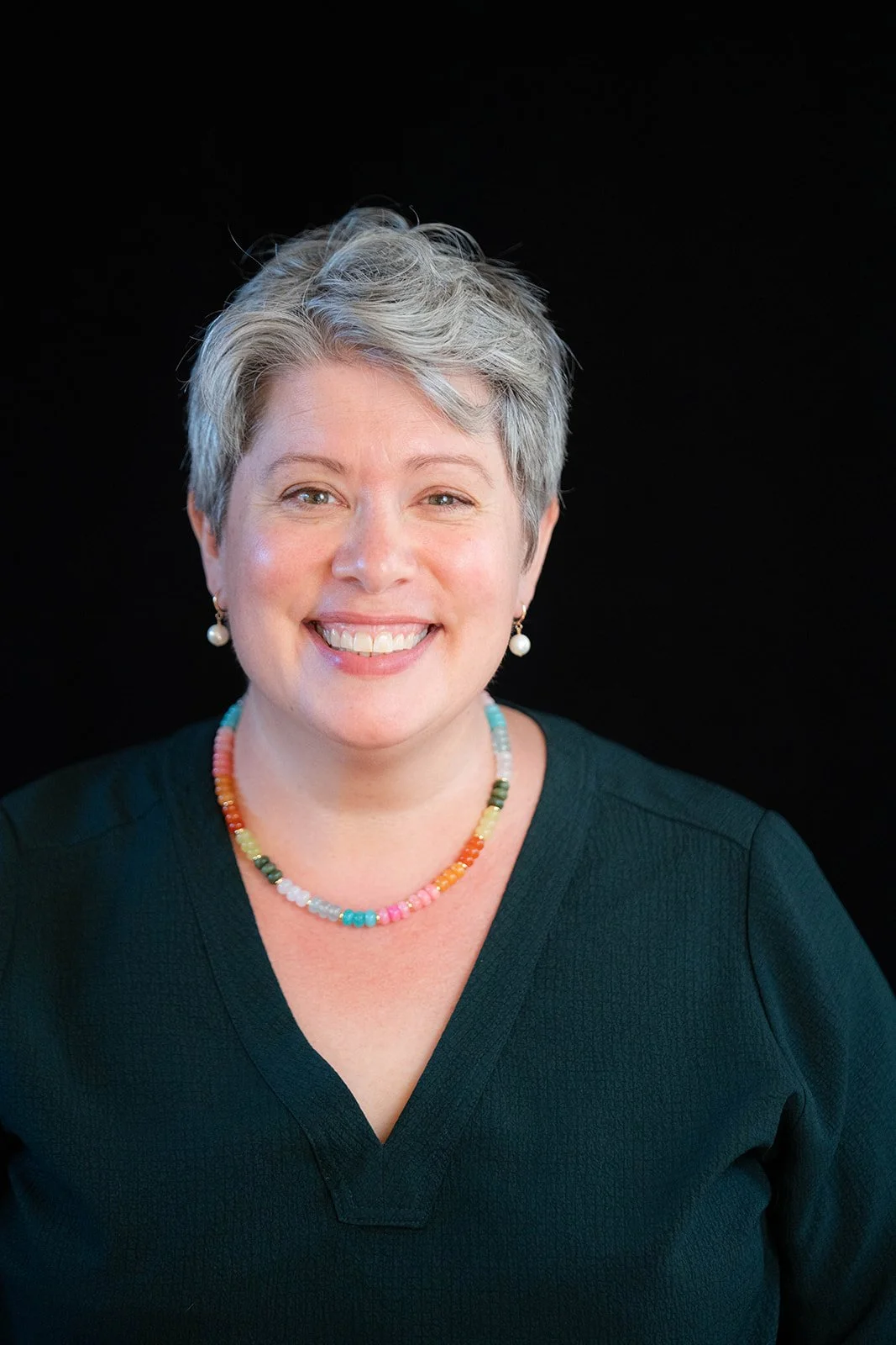 Torrey Podmajersky, a pale woman with gray hair, smiles at the camera.