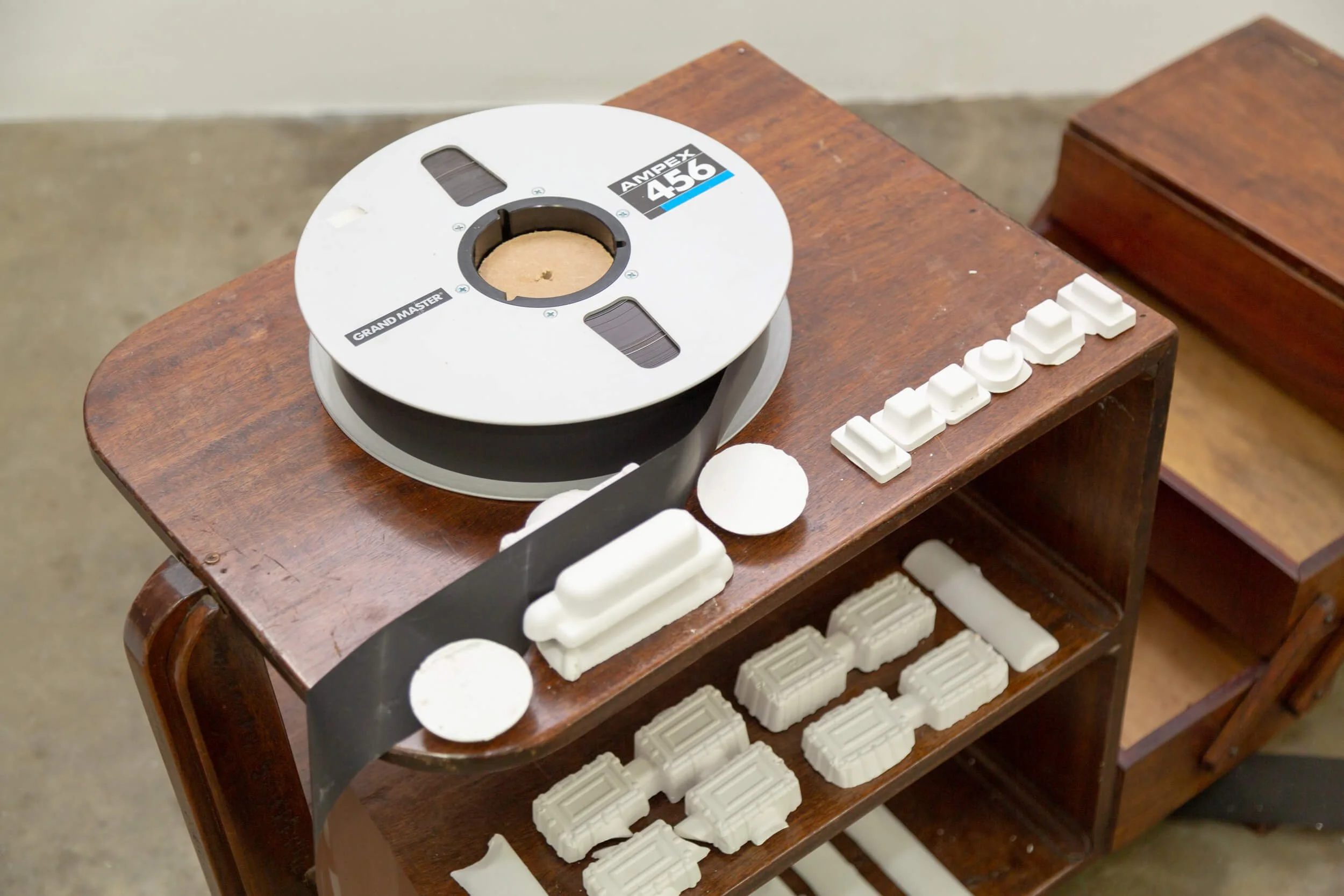 A wooden table with a reel of film, the word "LOVE" spelled out in white letters, and wax seals and wax seal stamps.
