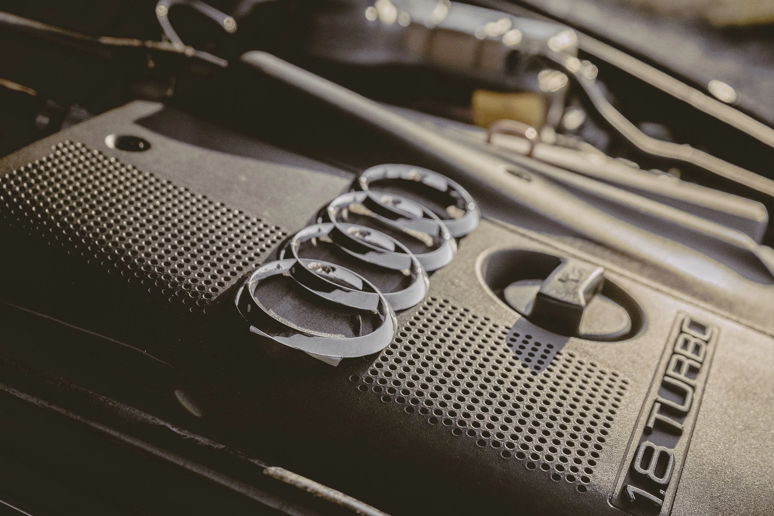 Ansicht des Motorraumdeckels eines Autos mit dem Audi-Logo und der Aufschrift 'TDI'.