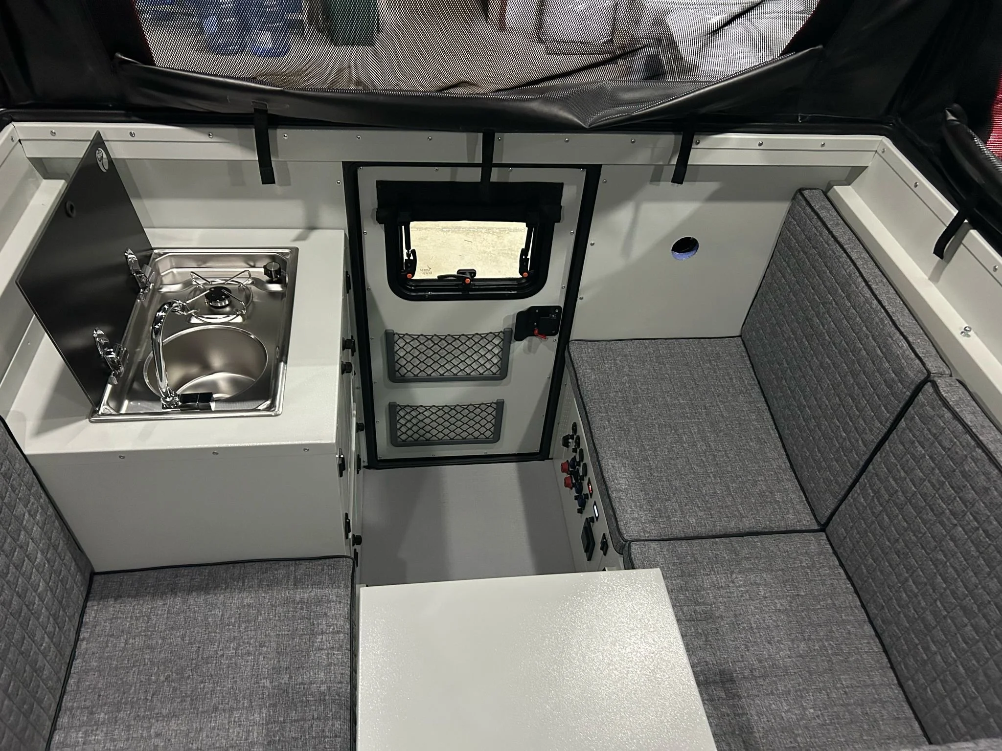 The Decamp Backpack M demountable camper cell. Designed for both double cab and single cab configurations. With an extra 31 cm of width, it offers a spacious interior and a full-size bed ideal for family use. Engineered for off-roading, overlanding, 