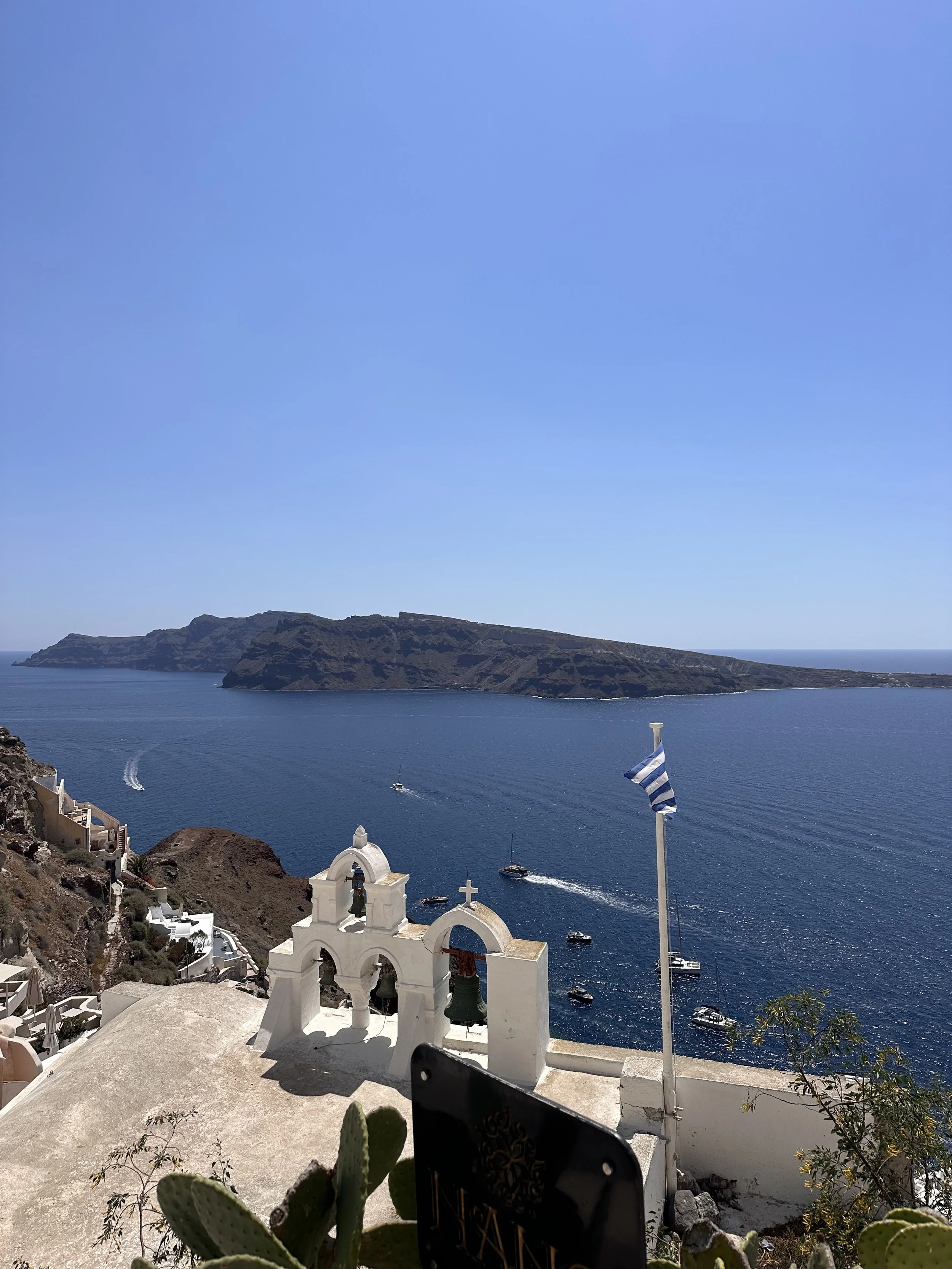 View of Ocean from Oia with Greek Flag