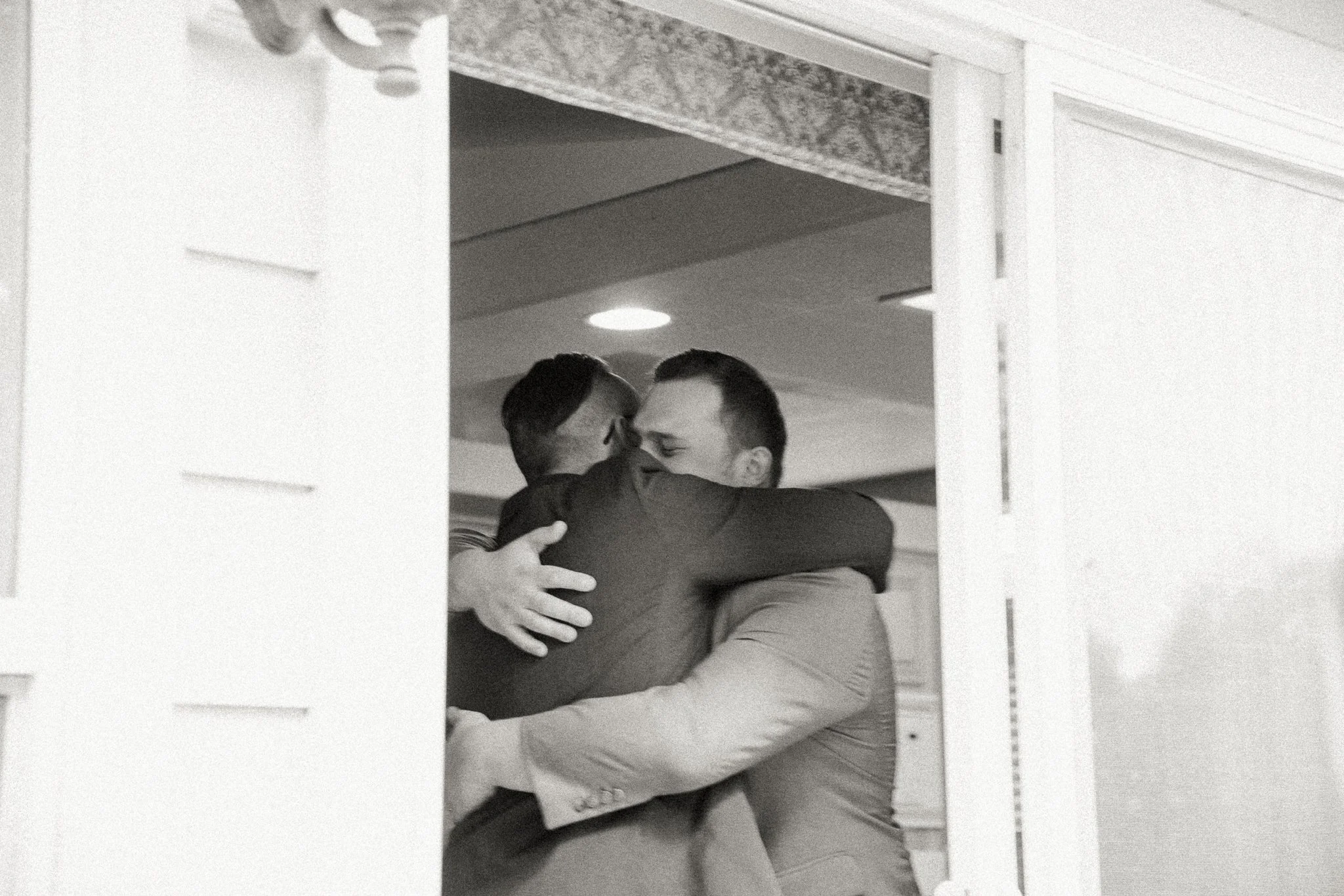 Two men hugging each other in an office setting