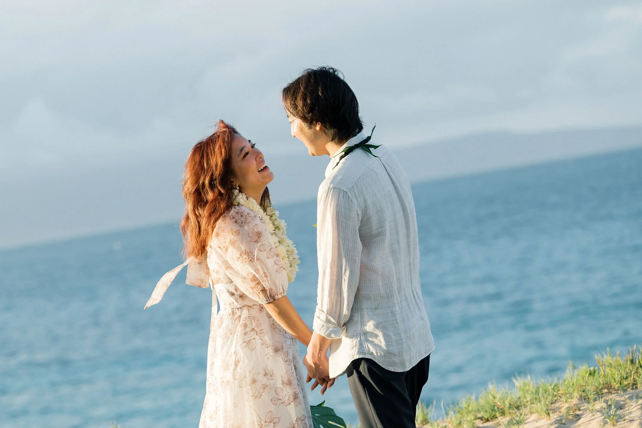 Surprise engagement photography in Maui, Hawaii by Lesley Casle Photo overlooking the ocean with Hawaiian lei flowers.