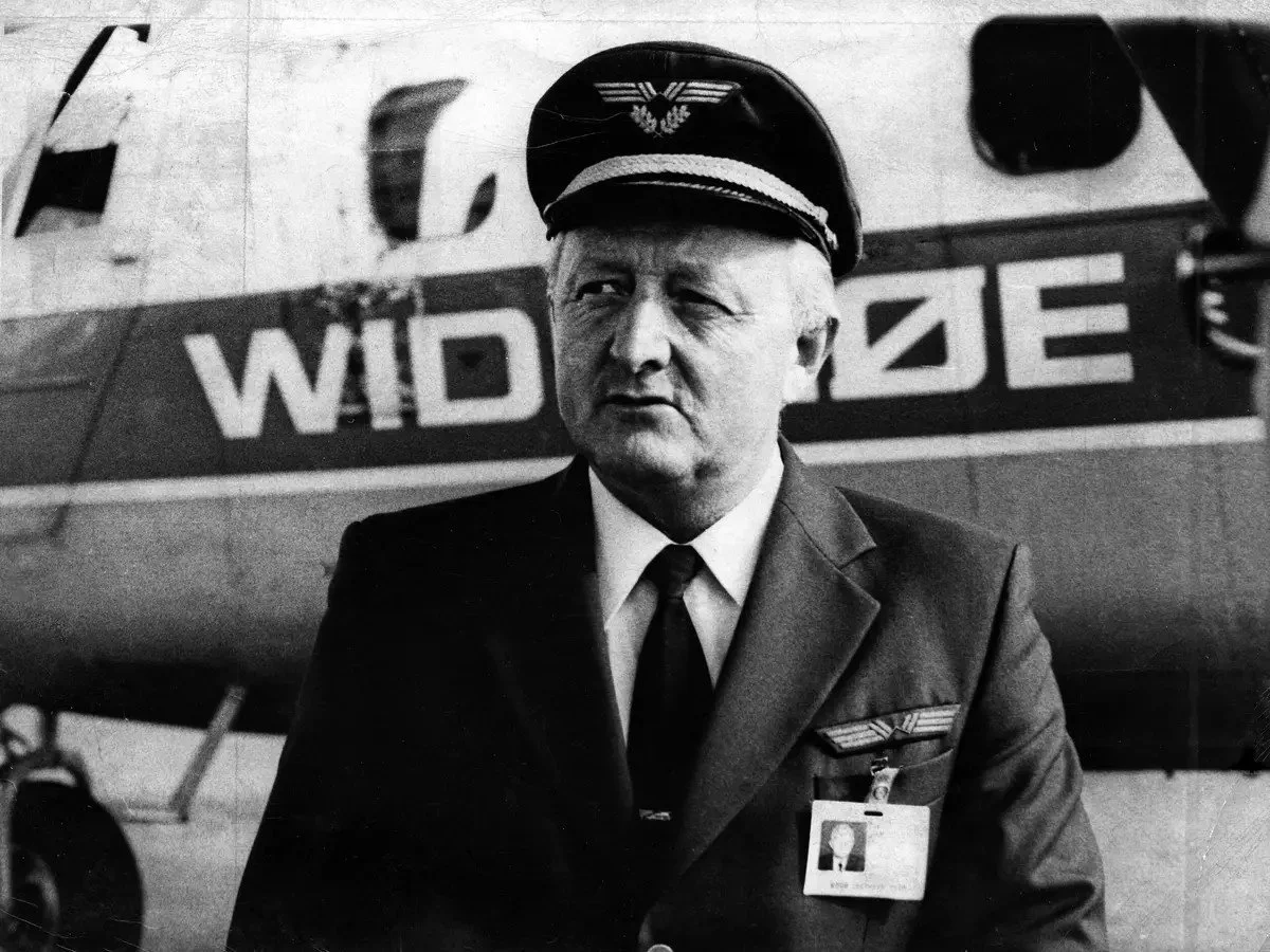 Foto viser Widerøe pilot Erik Langset foran et Widerøe fly.