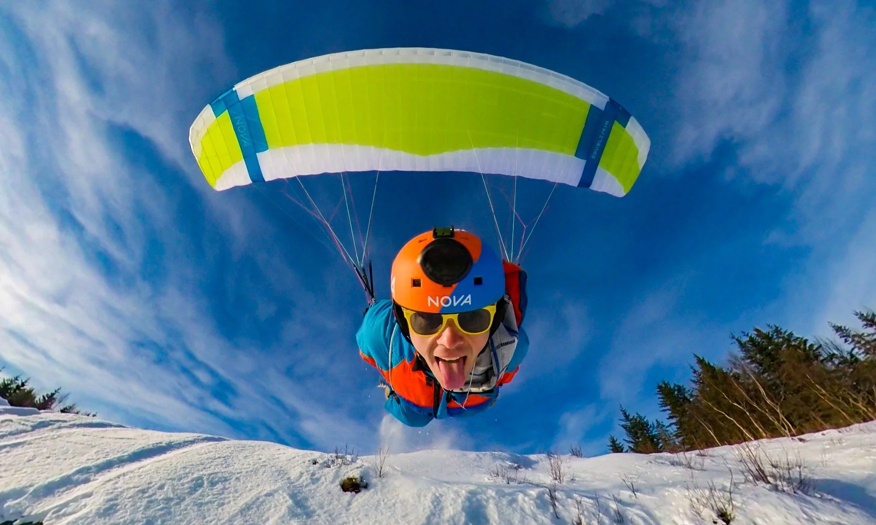Foto viser paragliderpilot Ole Dalen i lavt svev over et snøkledt landskap.