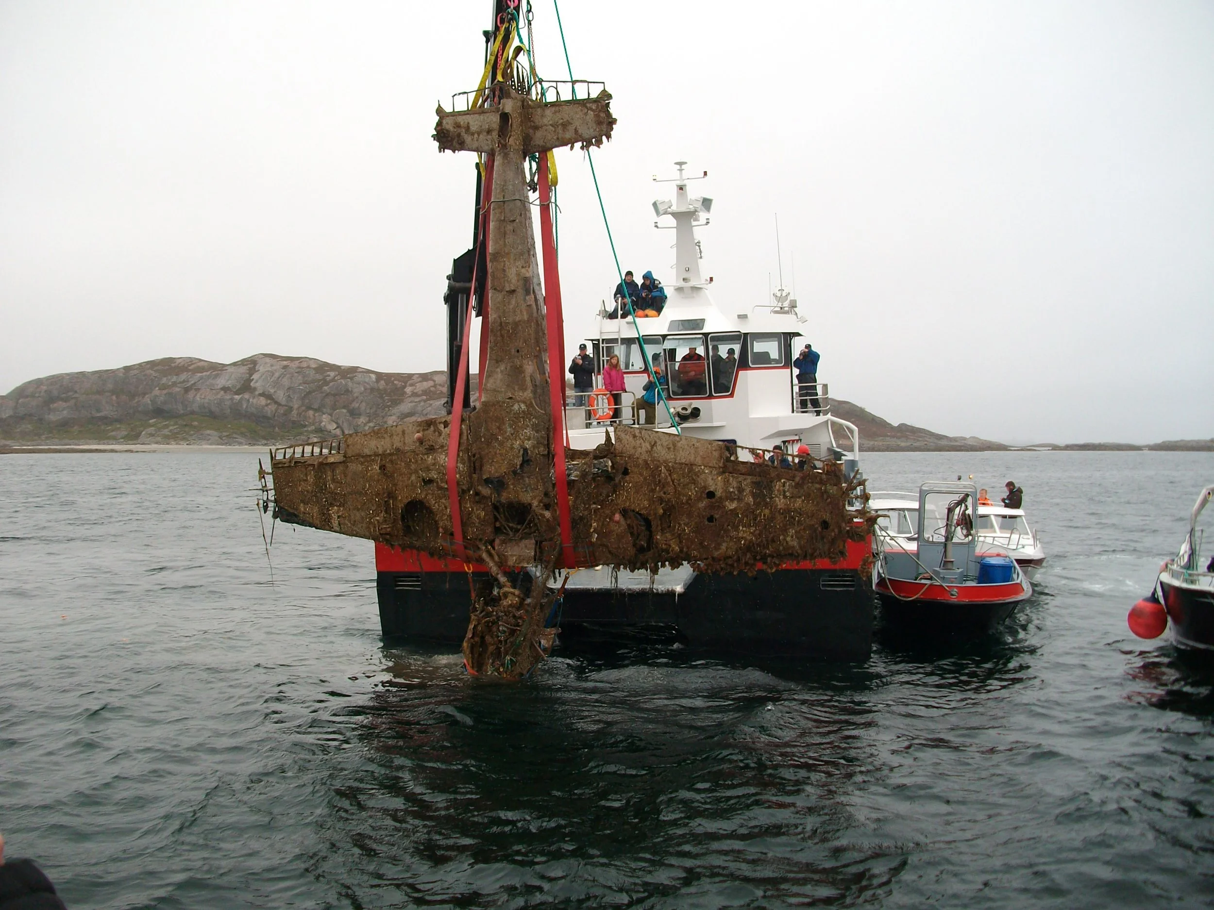 Bilde av Gul 3 heves fra havet 22. mai 2010. Ti tonn kraft i vinsjen måtte til for å løsne flyet fra mudderet. Foto: Bodø Luftfarthistoriske Forening