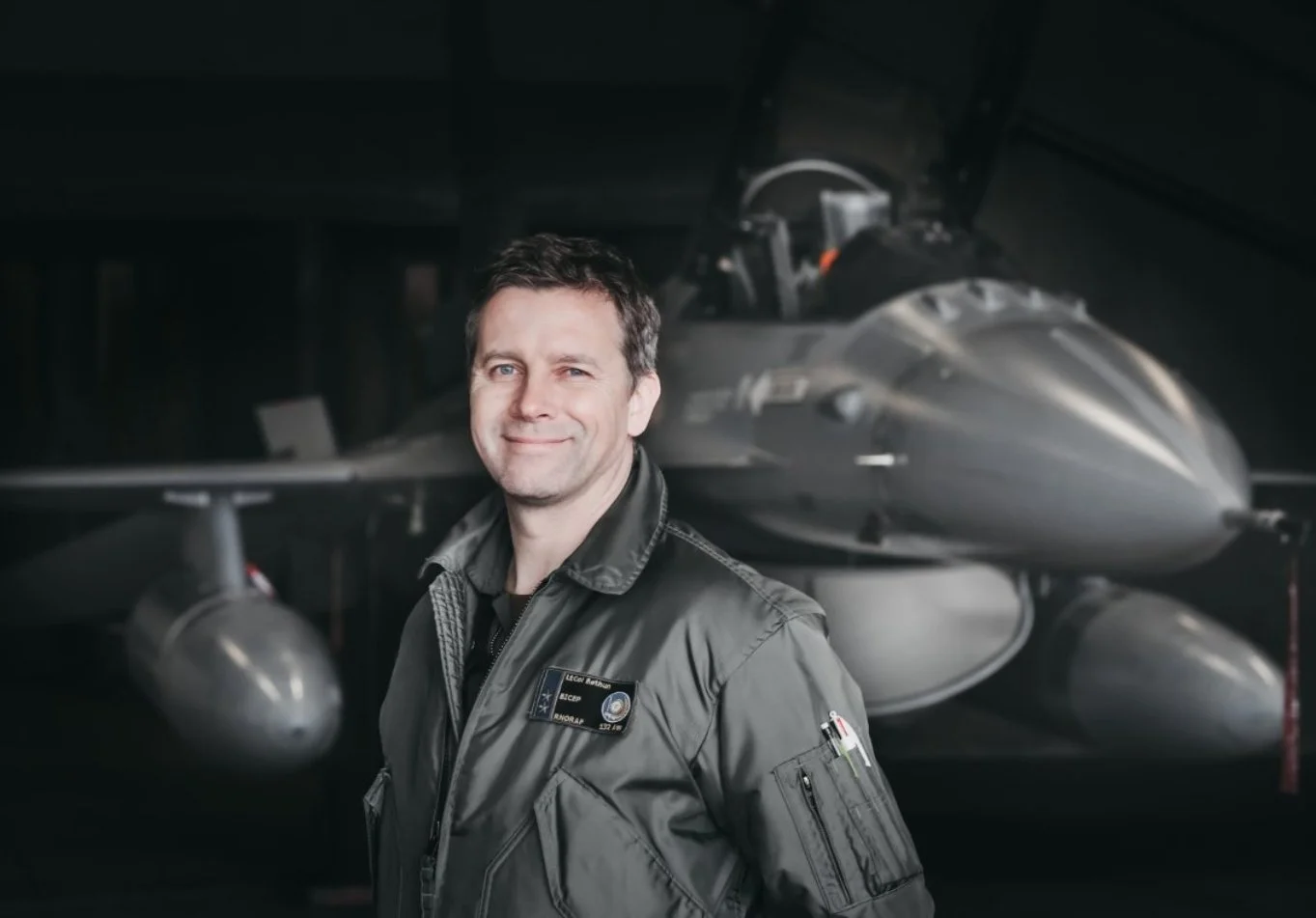 Foto viser pilot Vegard Bøthun med et F-16 jagerfly i bakgrunnen.