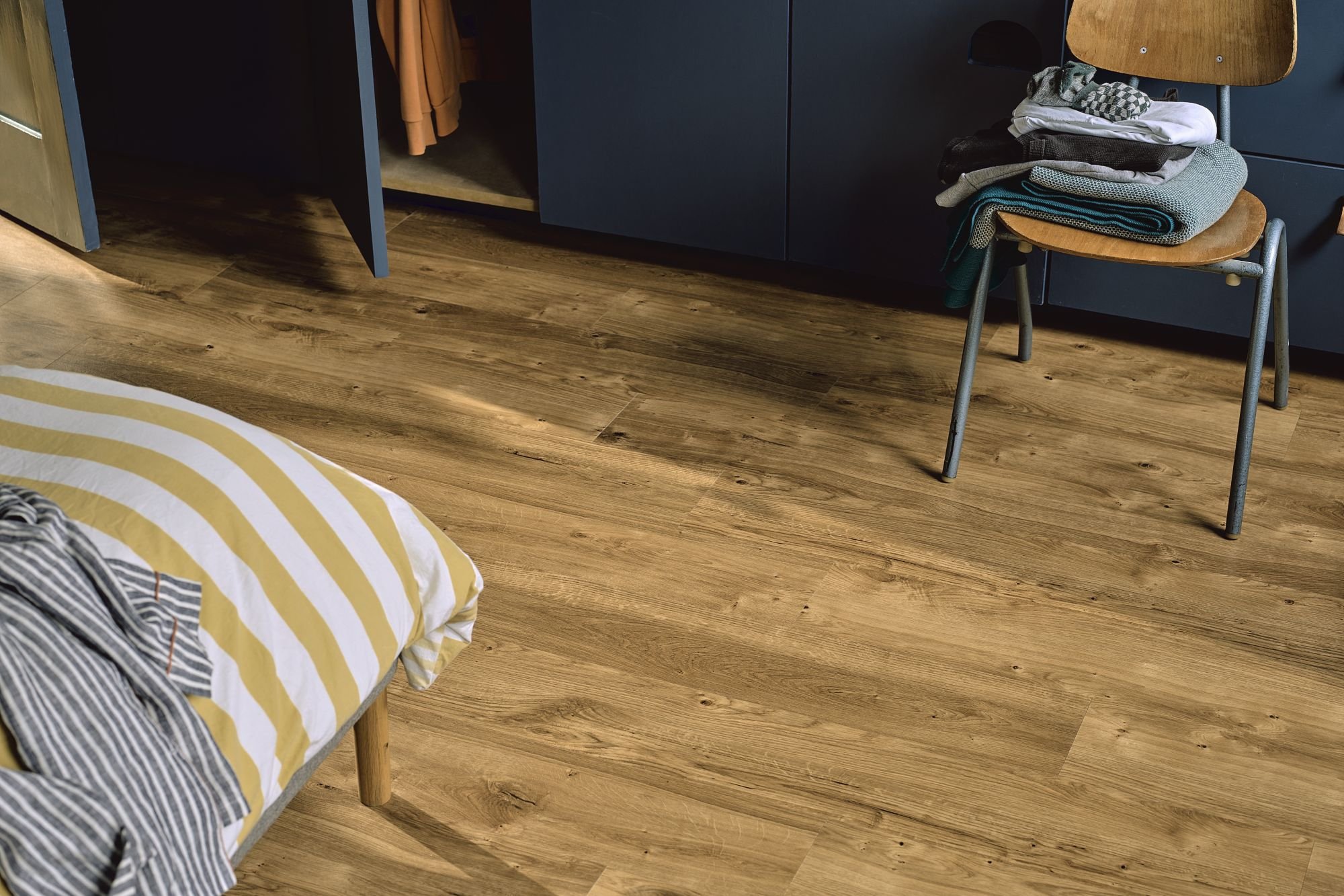 living room with a beige sofa, colorful pillows, and herringbone flooring